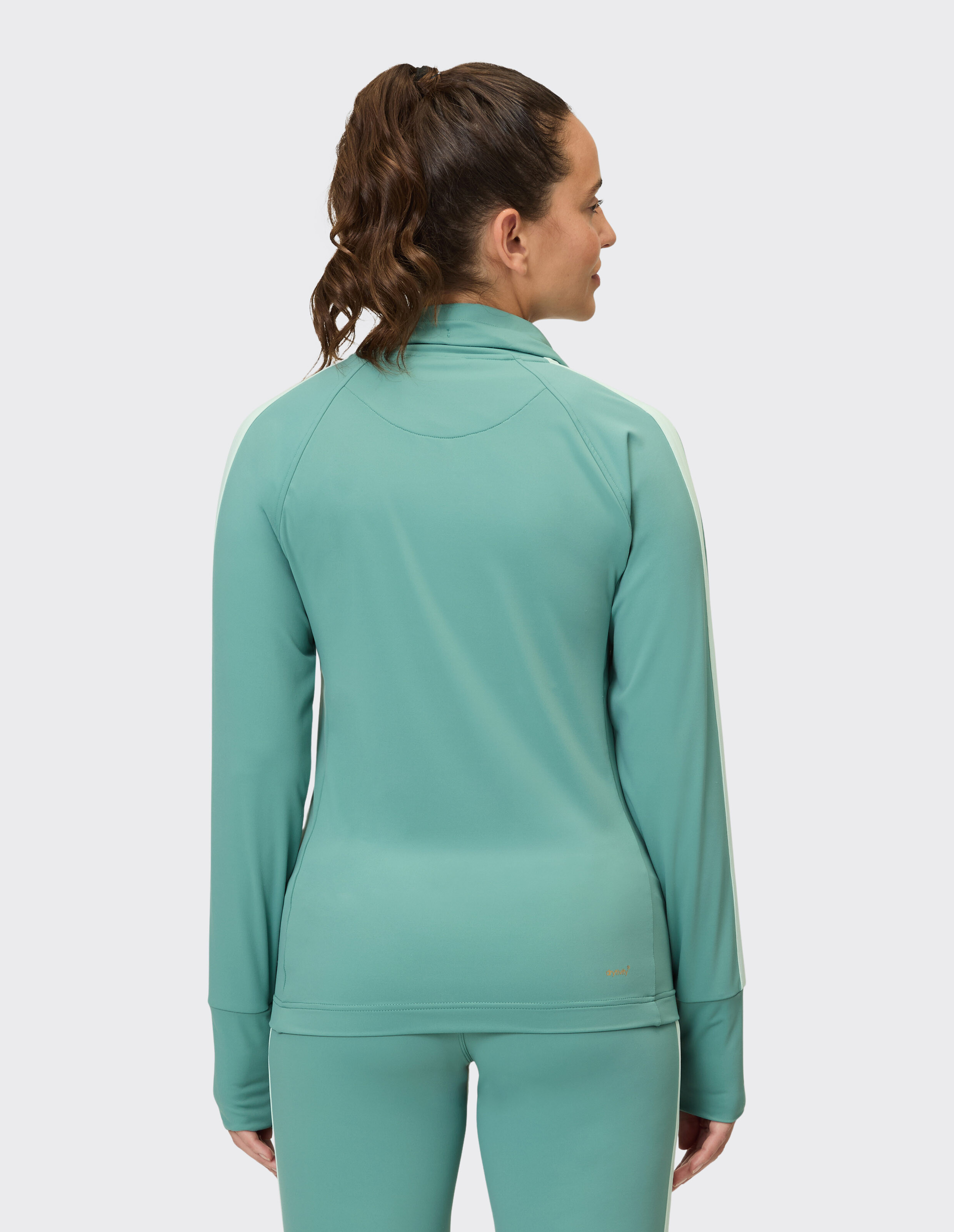 Rückansicht einer Frau in einem mintgrünen, langärmligen Sporttop.