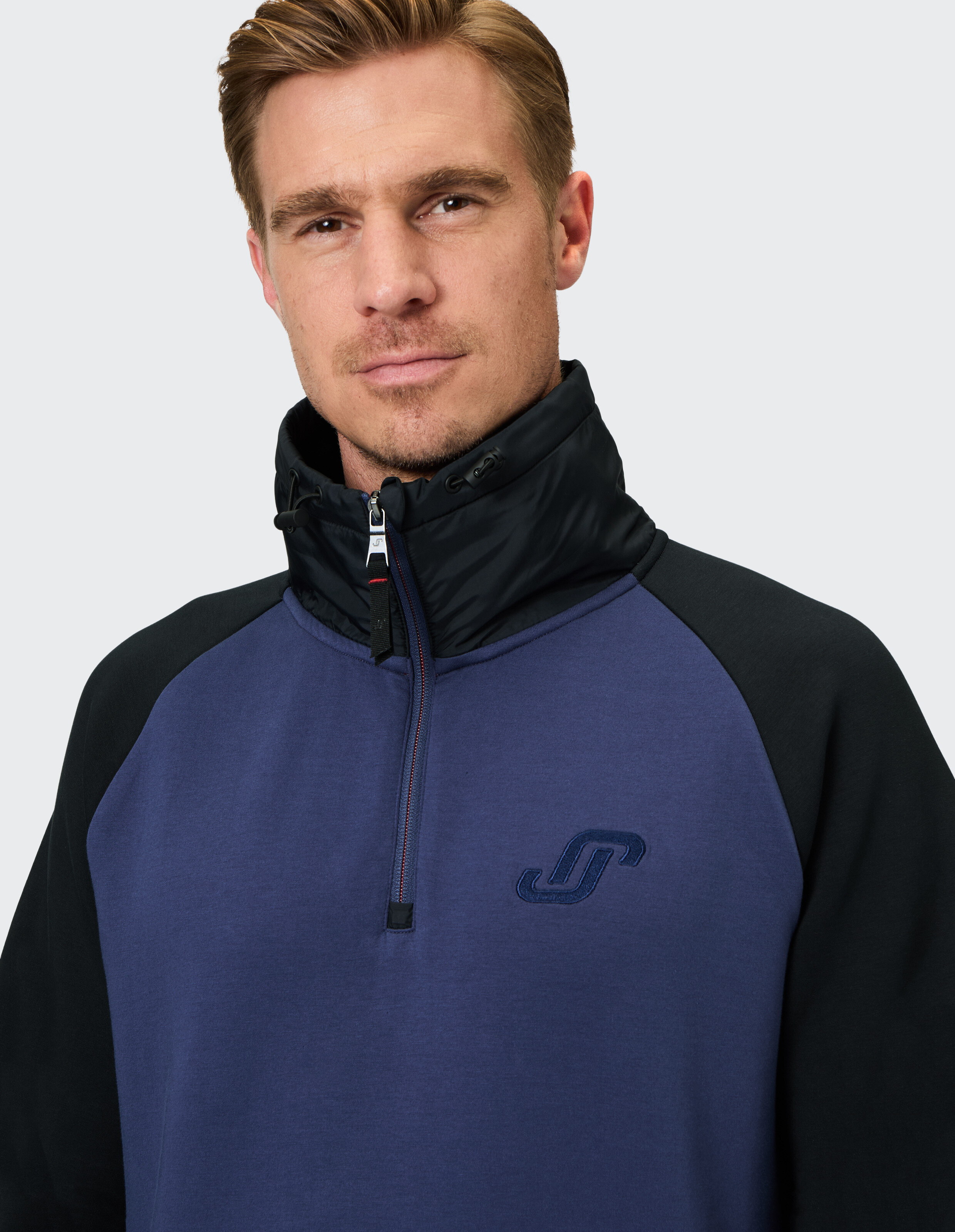 Kuscheliger Herrenpullover in Marineblau mit schwarzen Akzenten und Kragen mit halbem Reißverschluss.