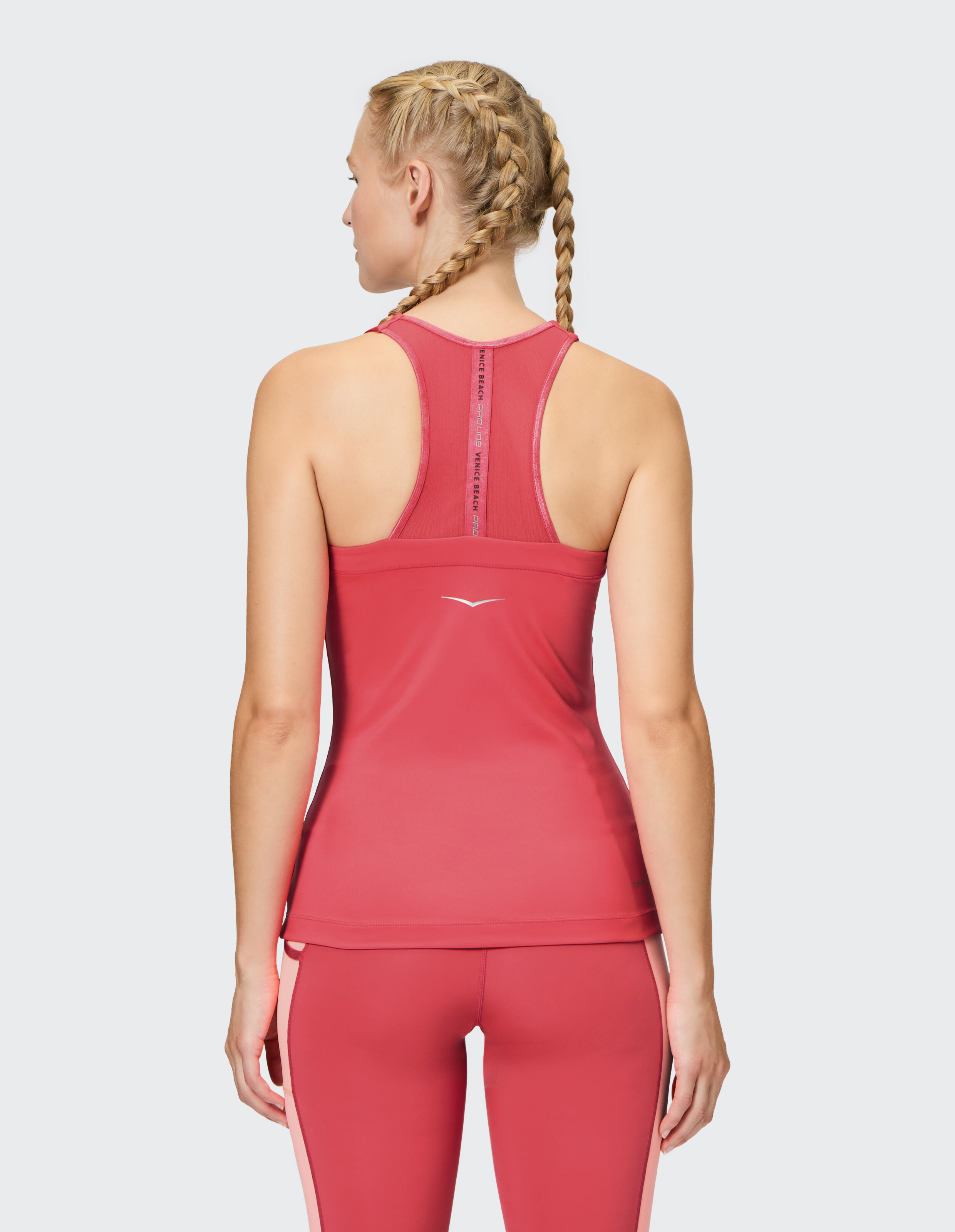 Rückansicht einer Frau in einem rosa Sport-Tanktop, perfekt für ungezwungene Trainingseinheiten.