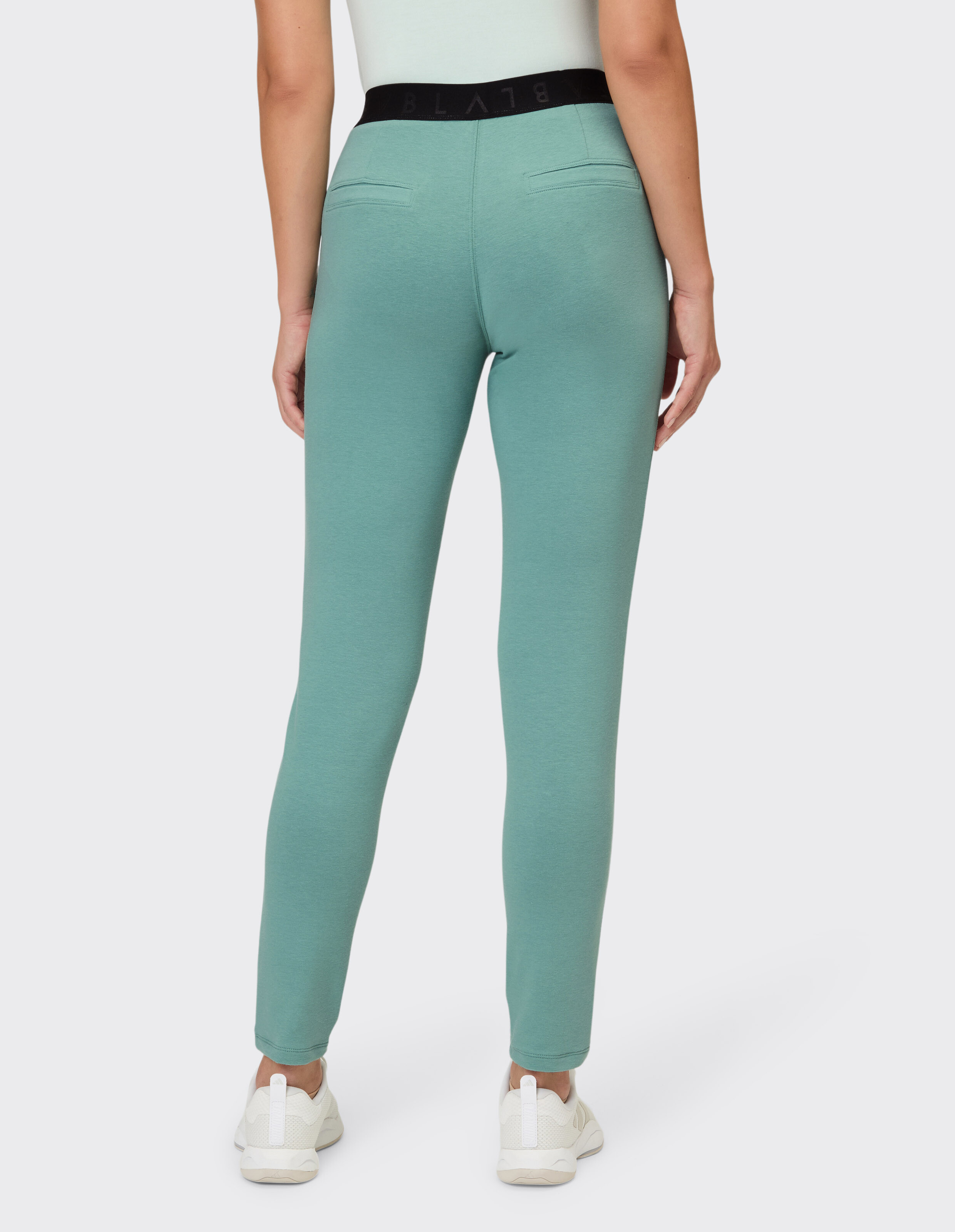 Rückansicht einer salbeigrünen Freizeit-Leggings mit schwarzem Markenbund.