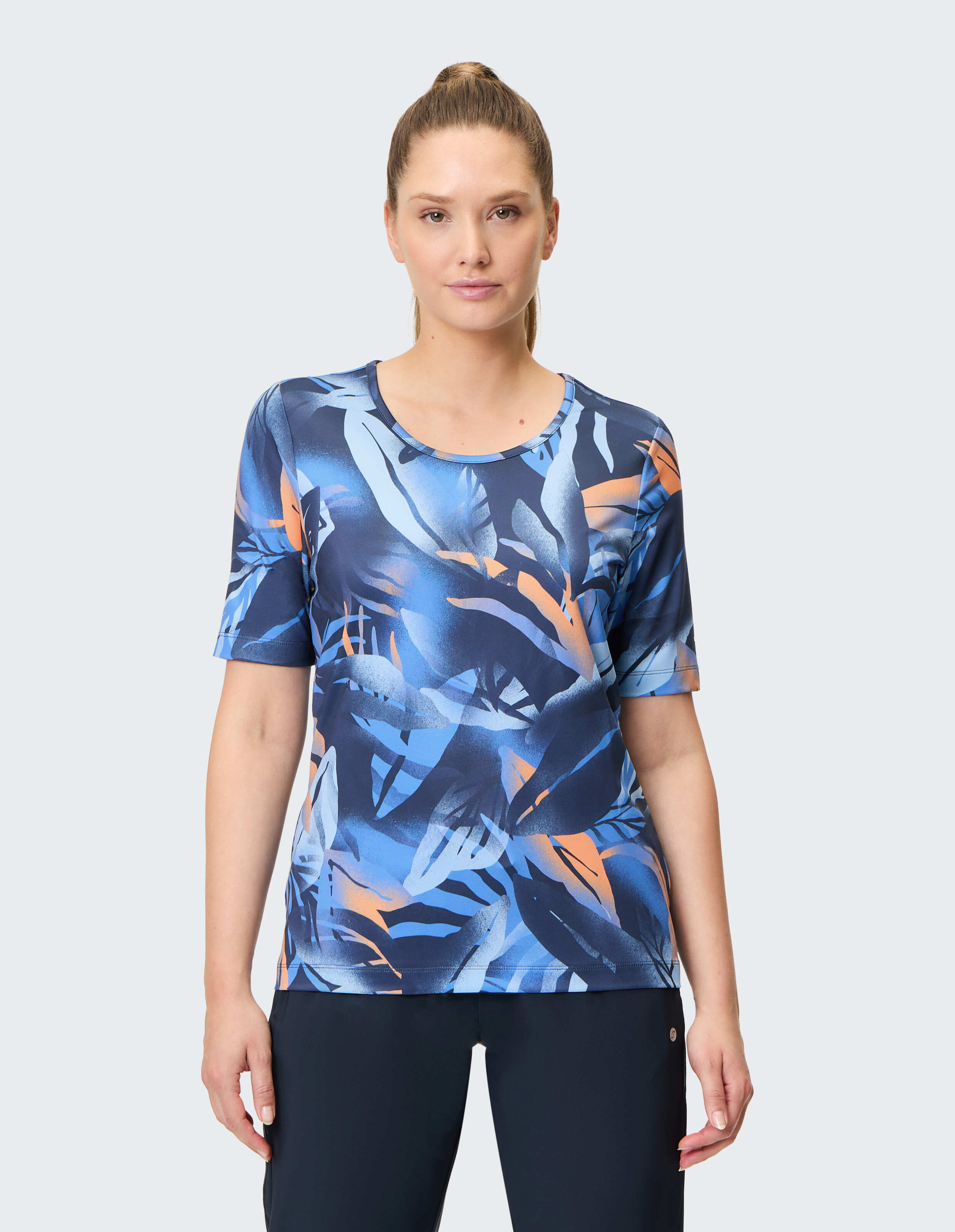 Kurzärmliges Damenoberteil mit leuchtend blauem und orangefarbenem Tropendruck.