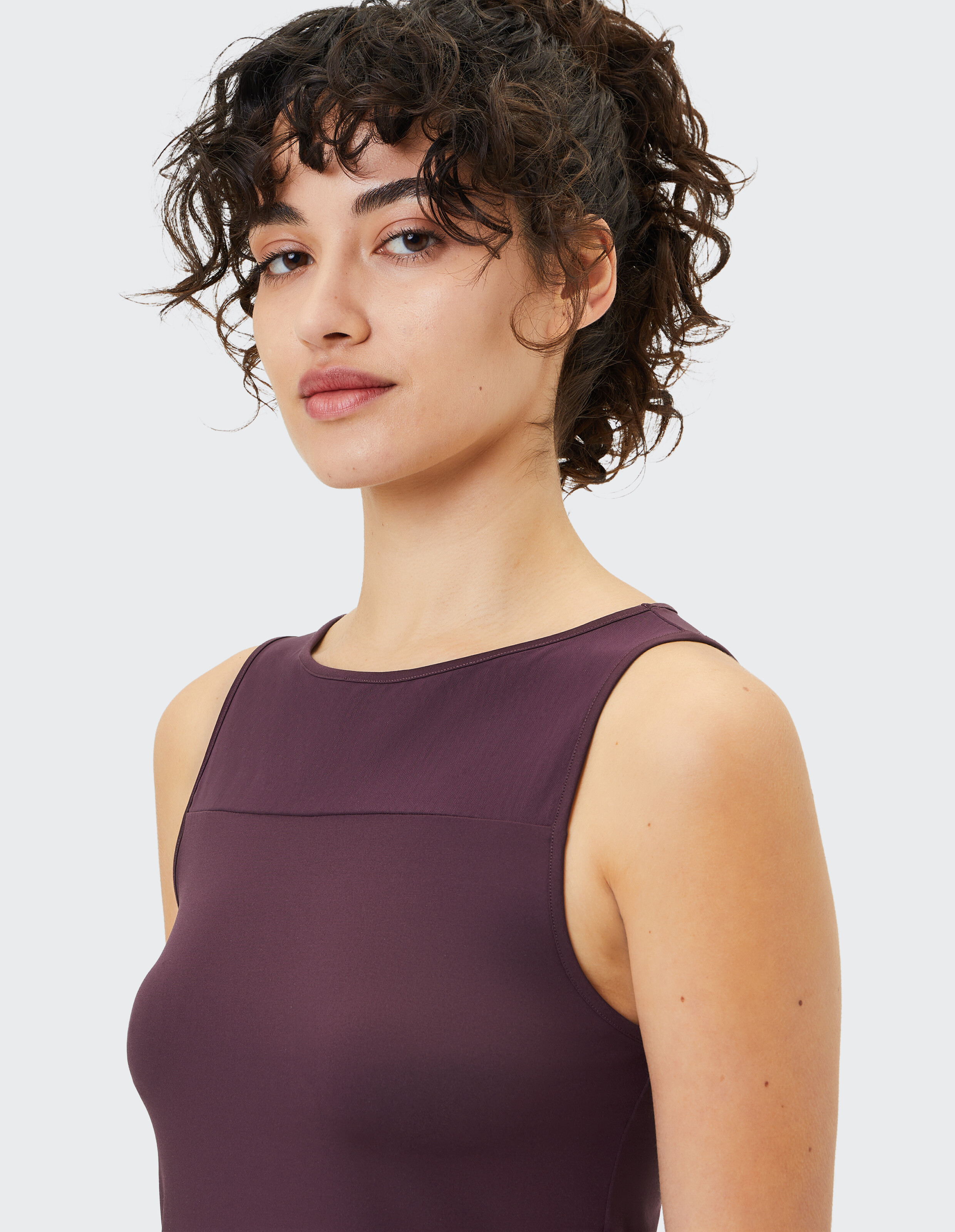 Frau trägt ein dunkelviolettes ärmelloses Oberteil, perfekt für bequeme Freizeit-Loungewear.