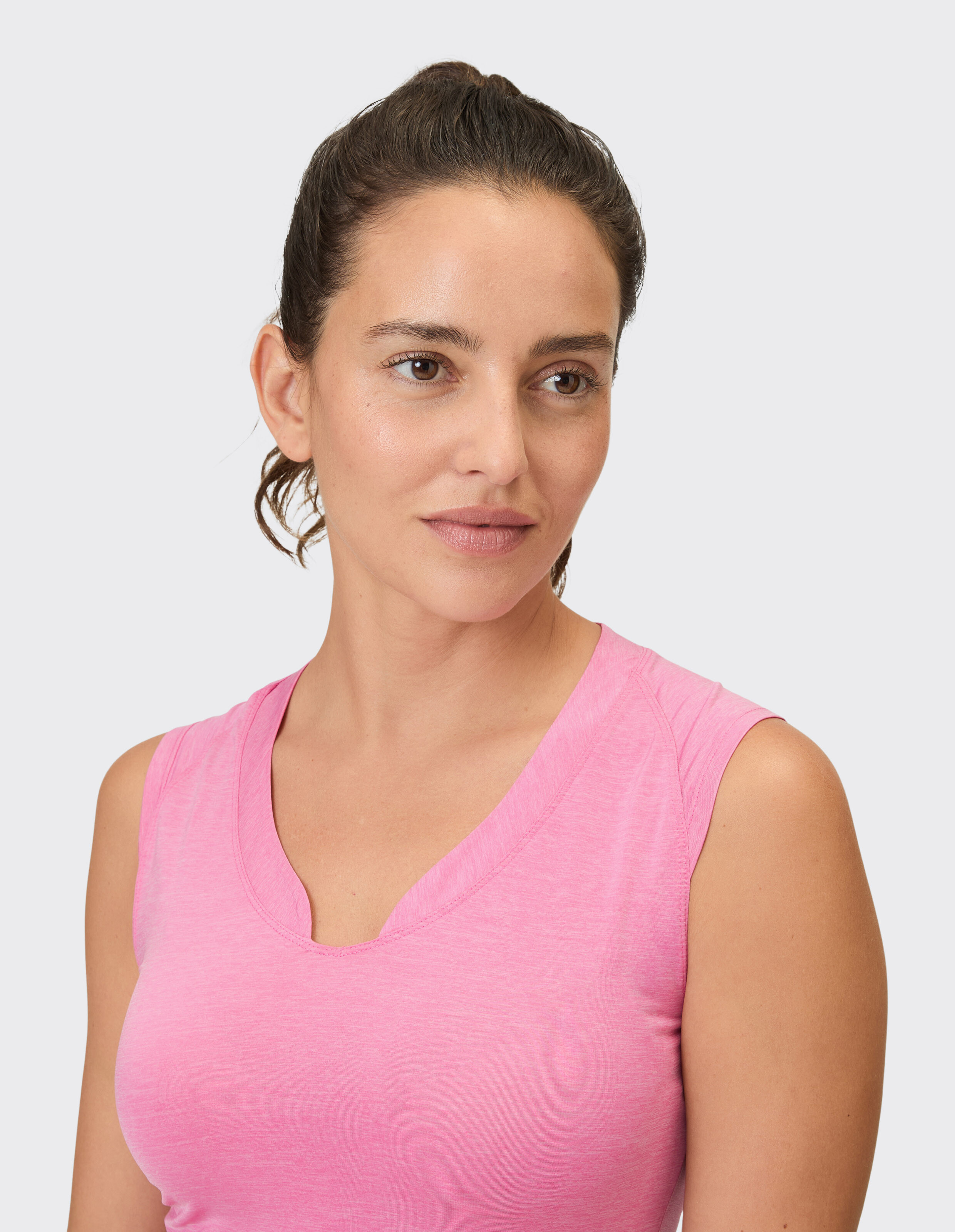 Nahaufnahme einer Frau in einem rosa ärmellosen Oberteil, das einen lässigen und bequemen Stil zeigt.