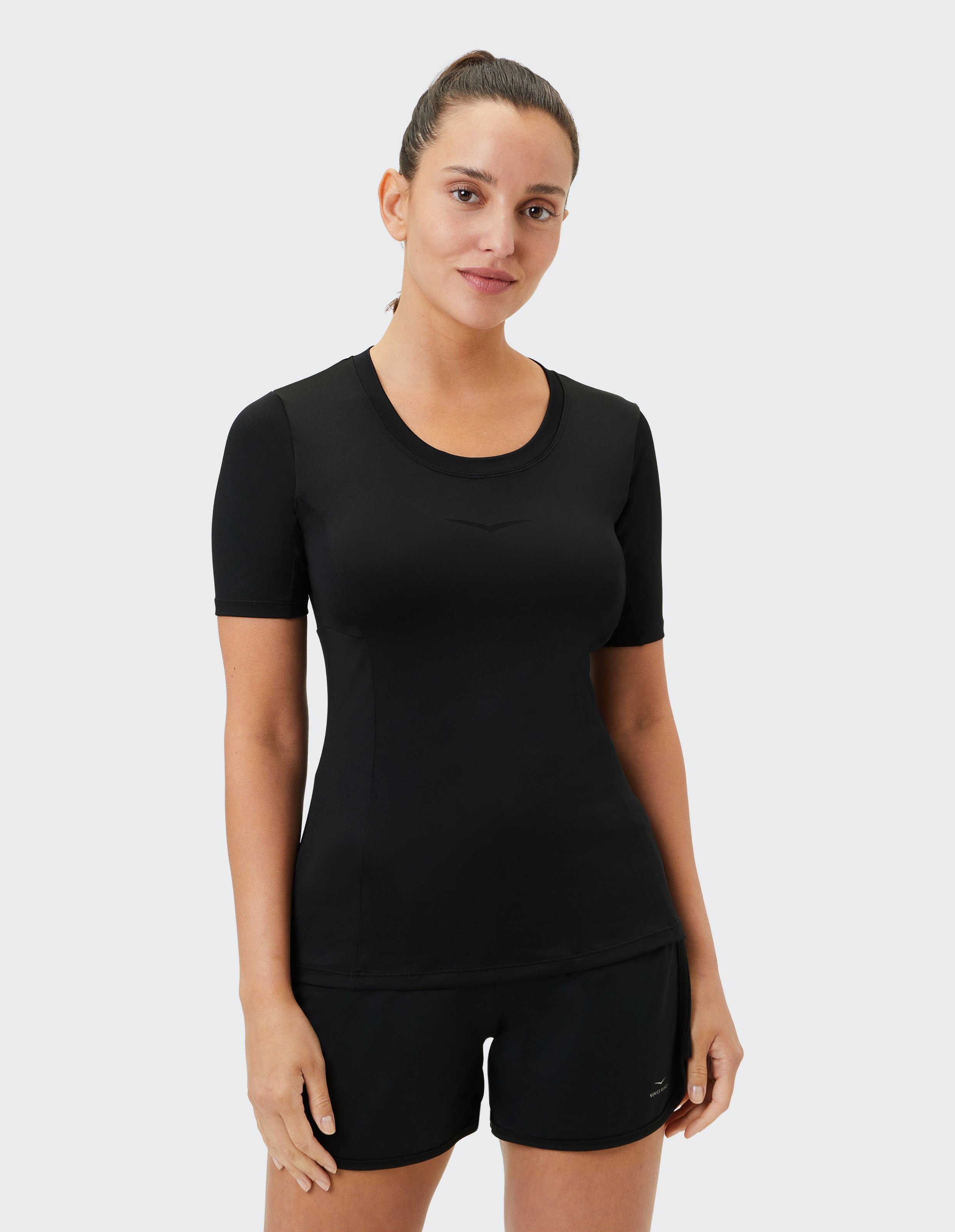 Schwarzes, kurzärmliges Sportoberteil gepaart mit passenden Shorts für Freizeitkleidung.