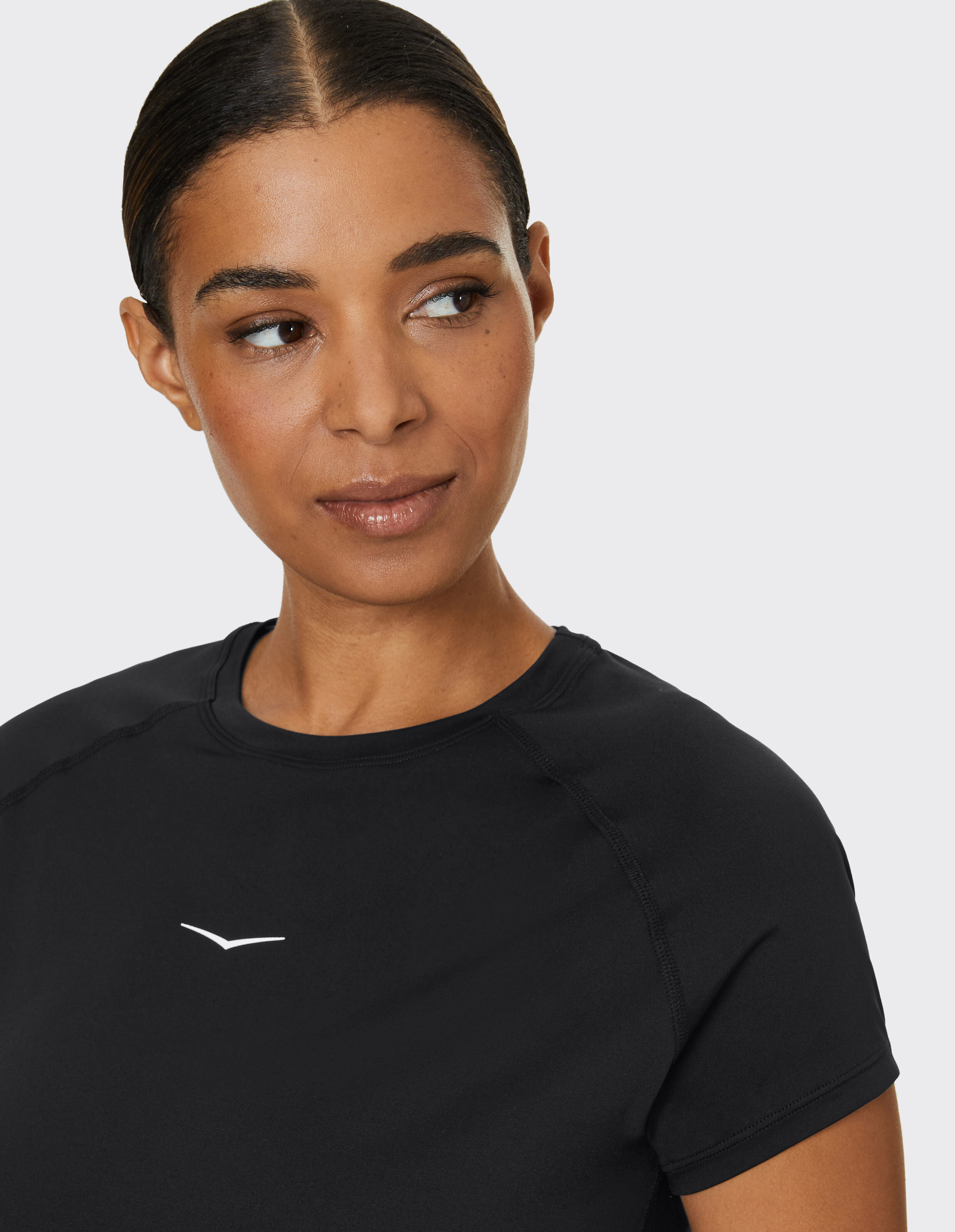 Frau trägt ein schwarzes lässiges Kurzarmshirt von Venice Beach Kurzarmshirt Oda.