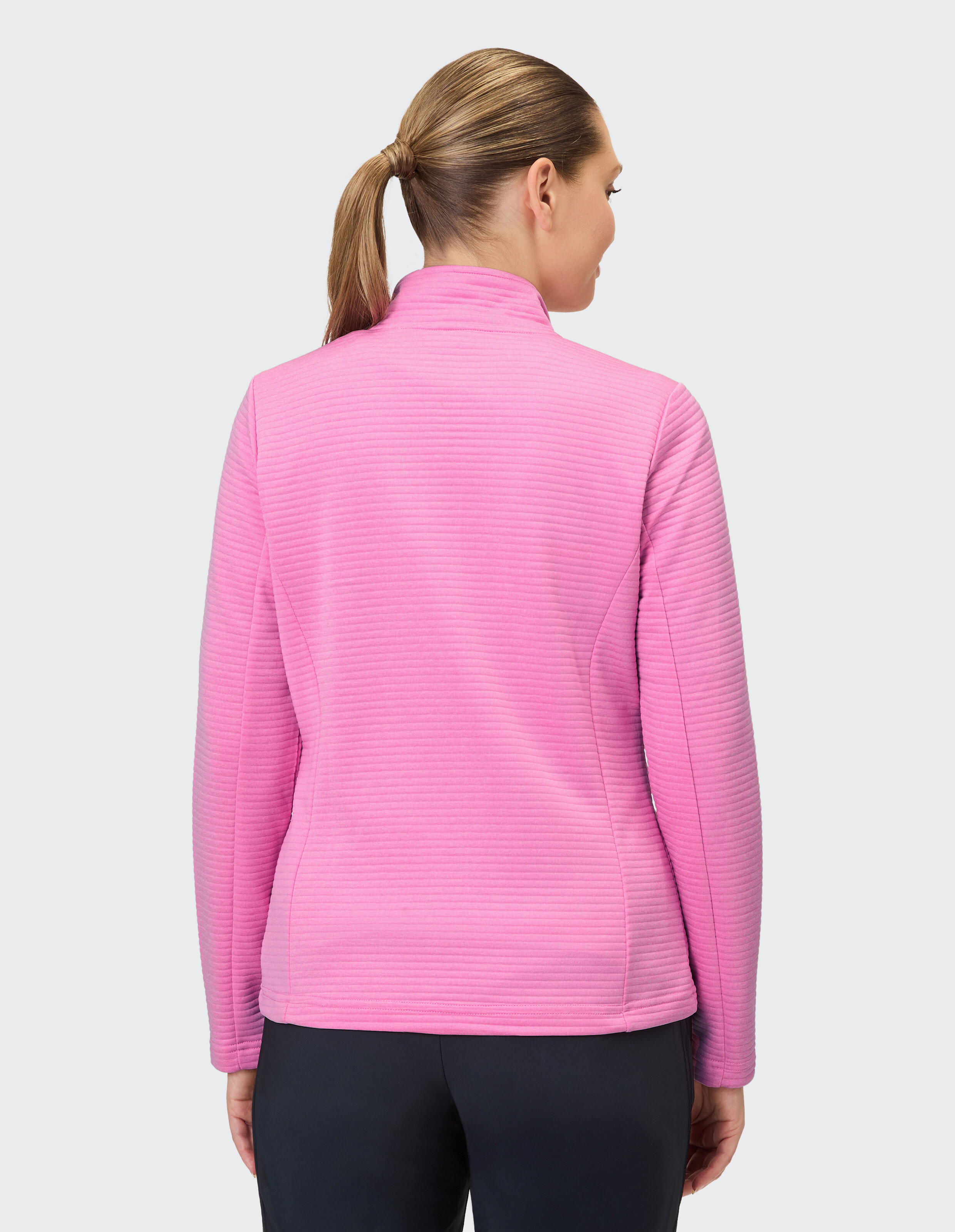 Rückansicht einer Frau in einem kuscheligen rosa Pullover, perfekt für Freizeitkleidung.
