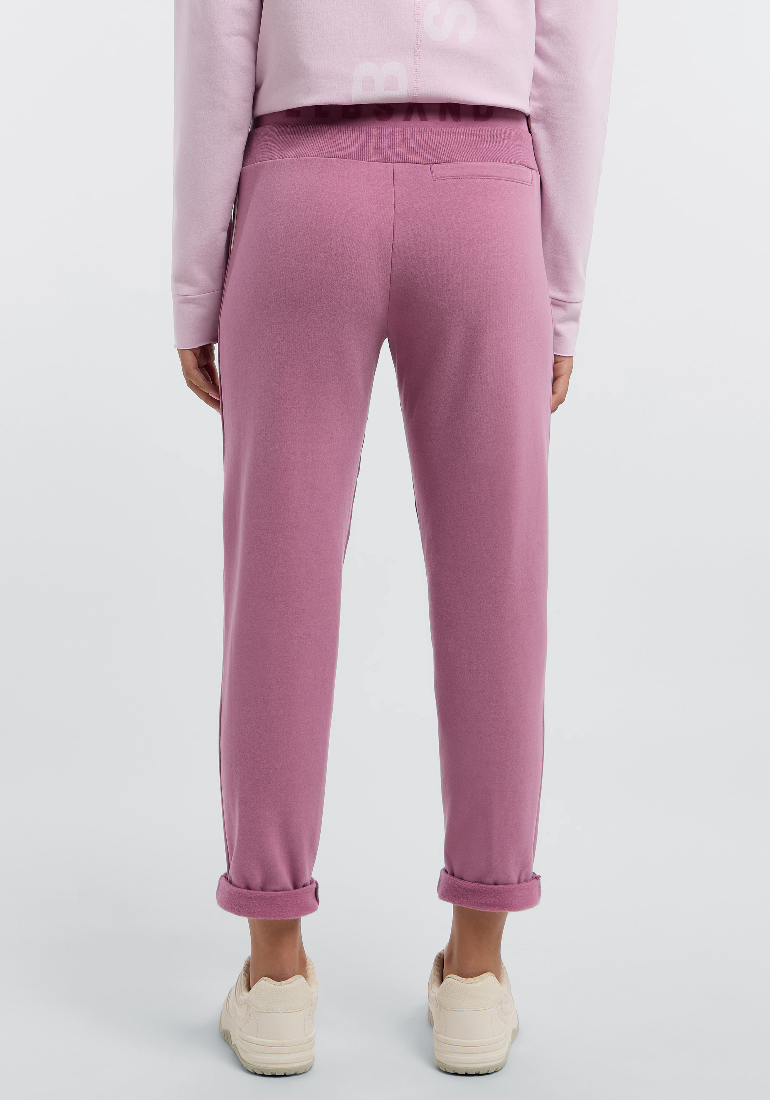 Rückansicht einer malvenfarbenen Freizeit-Jogginghose mit Markenbund für bequeme Lounge-Kleidung.