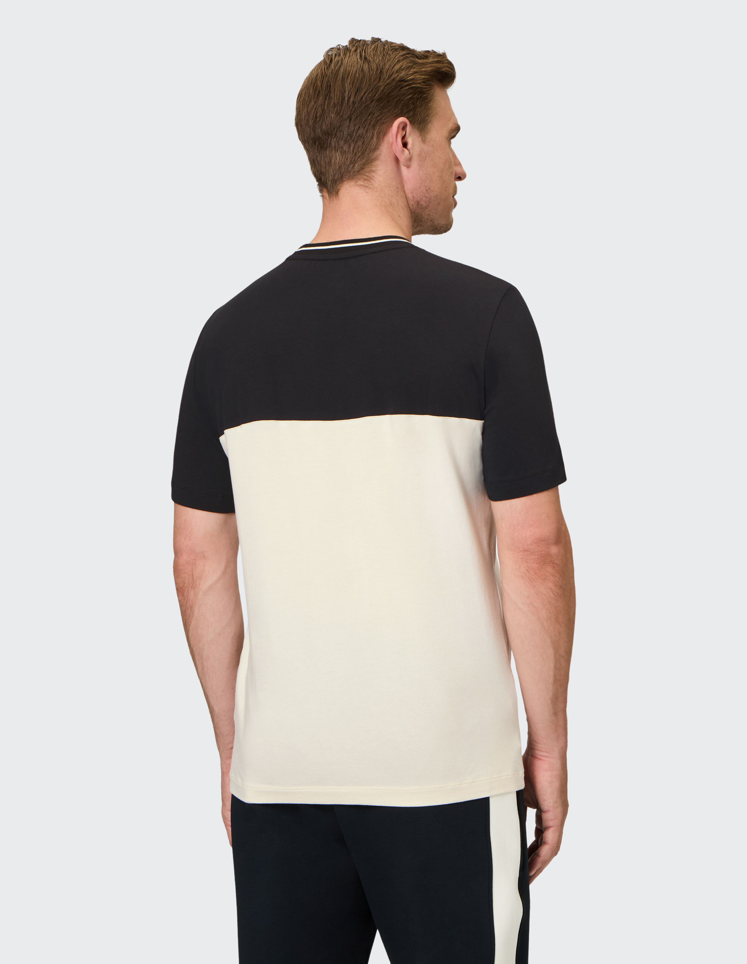 Lässiges Herren-T-Shirt im Farbblockdesign in Schwarz und Creme mit bequemer Passform und weichem Stoff, ideal für entspannte Ausflüge.