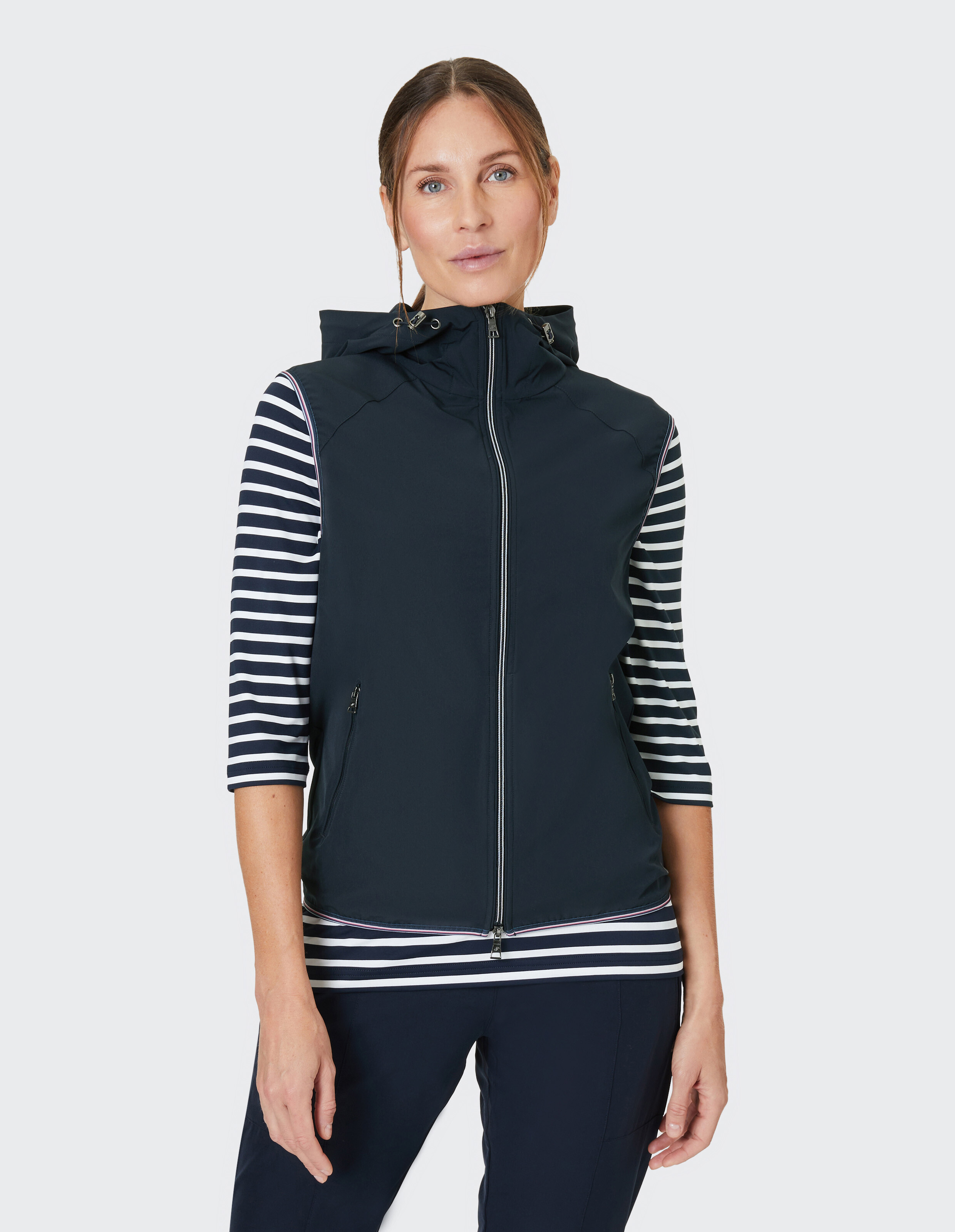 Ärmellose, dunkelblaue Weste mit Reißverschluss, zwei Taschen und Kapuze; sportliches Design für Freizeitkleidung.