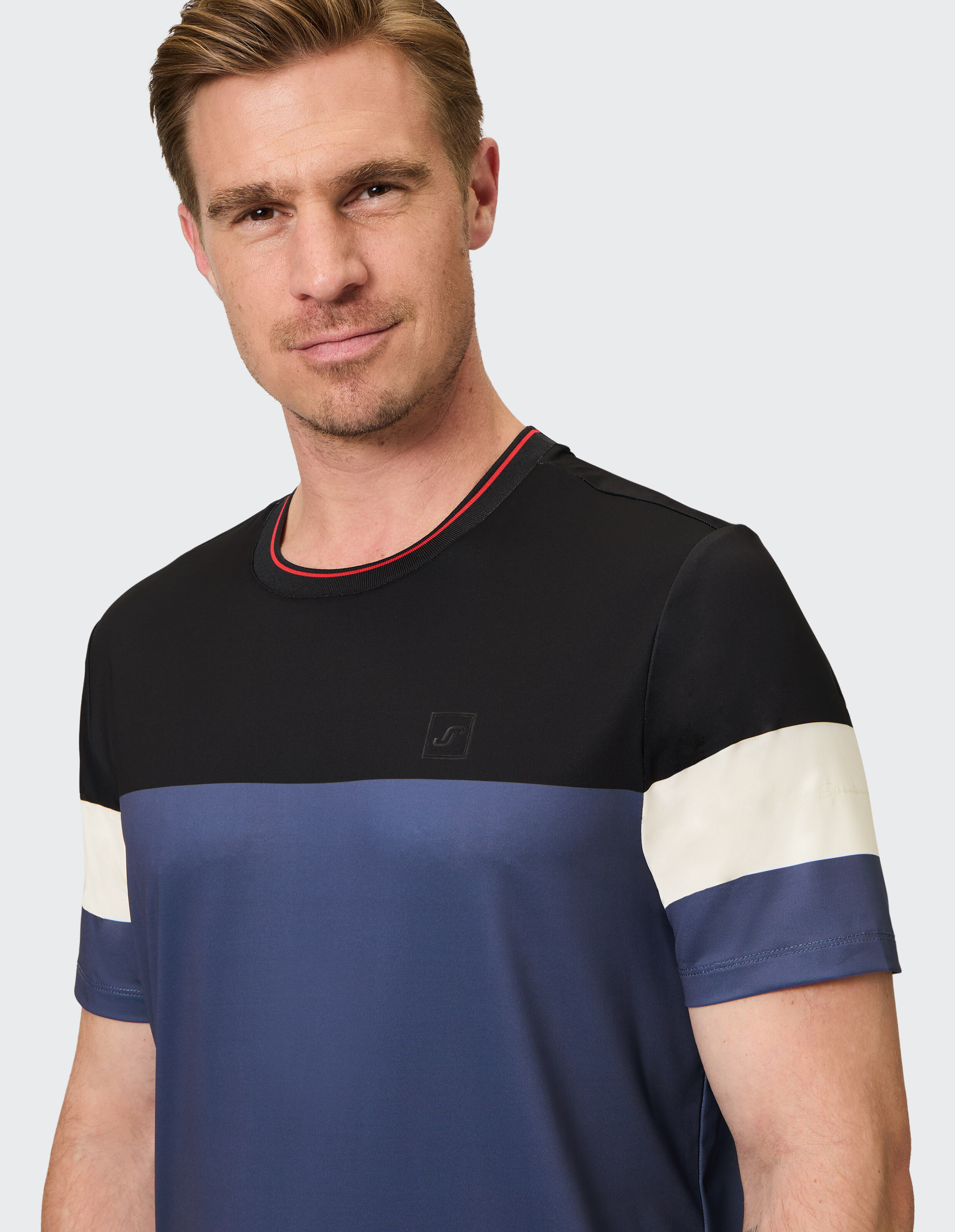 Mann trägt ein schwarz-blau-weißes, lässiges T-Shirt mit Farbblockdesign von ELBSAND.