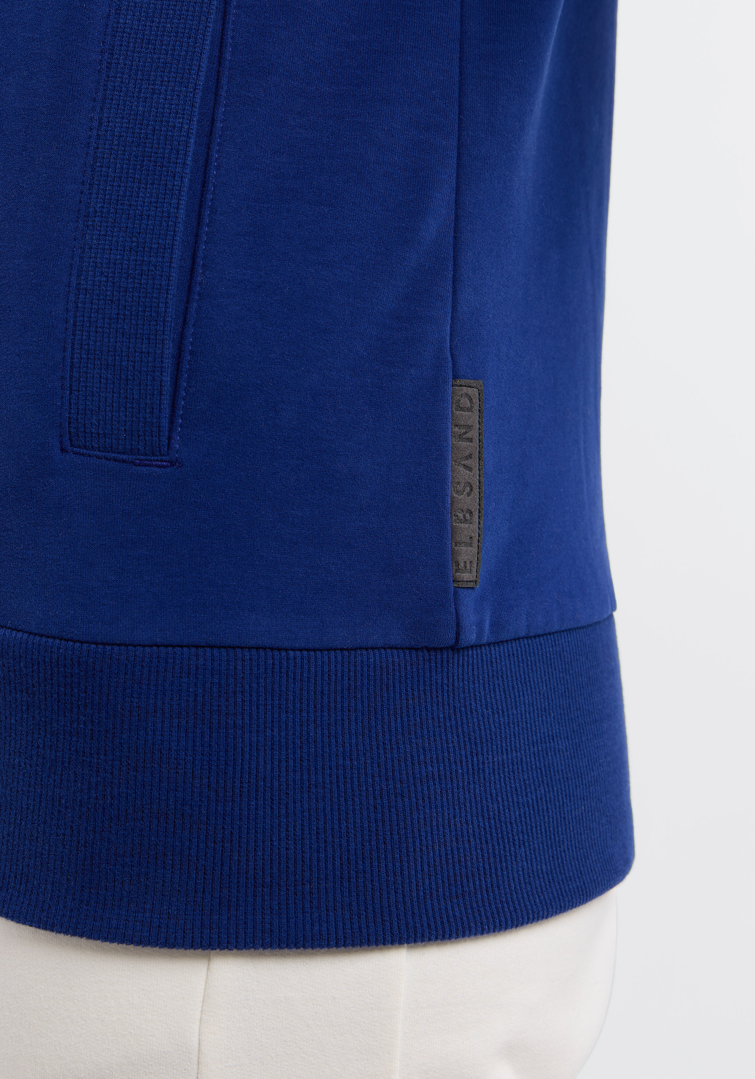 Nahaufnahme eines blauen ELBSAND-Freizeit-Sweatshirts mit geripptem Saum und Markenetikett.
