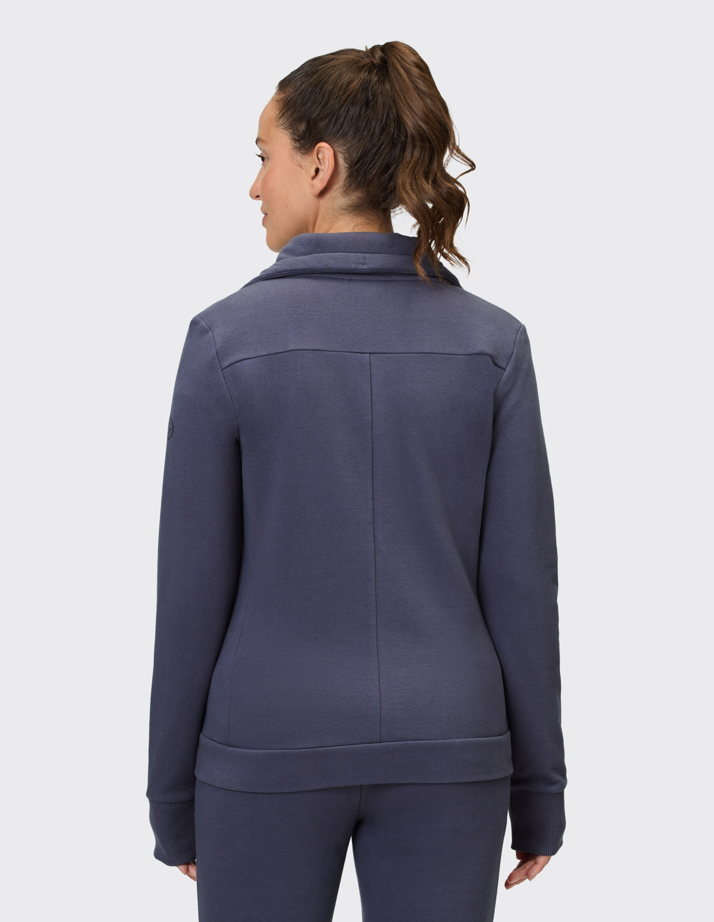 Rückansicht einer Frau in einer gemütlichen marineblauen Freizeitjacke, perfekt zum Entspannen.