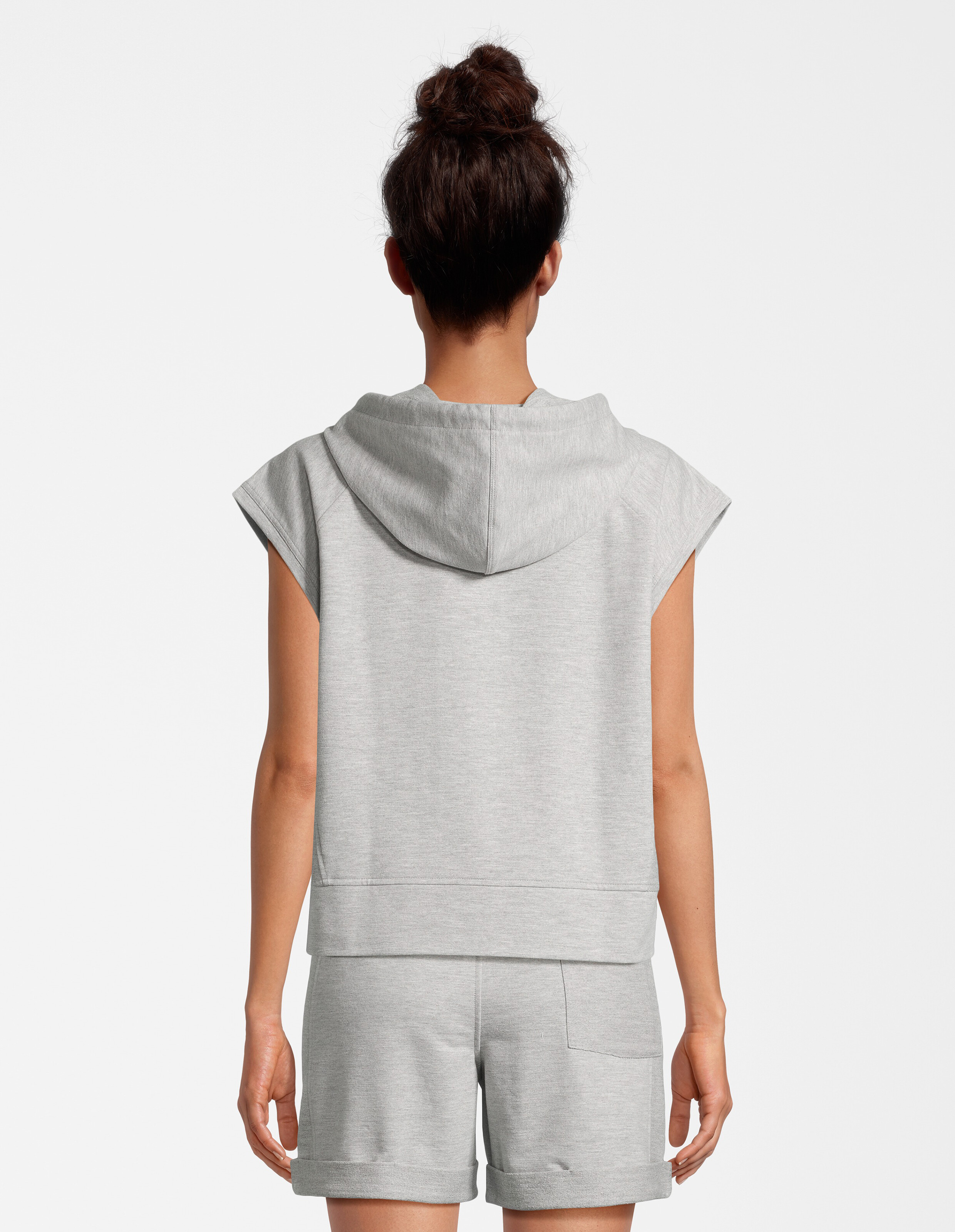 Rückansicht einer Frau, die einen gemütlichen grauen ärmellosen Kapuzenpullover und passende Freizeitshorts trägt.