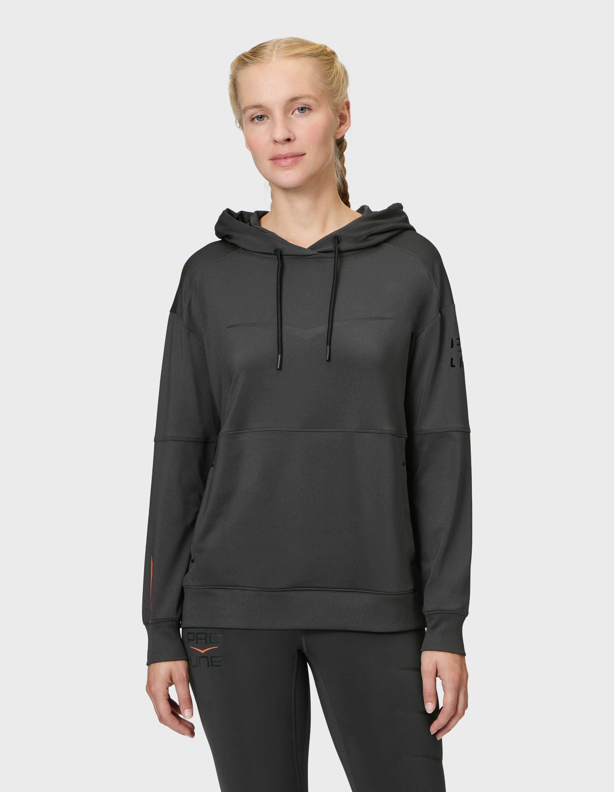Frau in einem kuscheligen schwarzen Kapuzenpullover mit entspannter Passform, perfekt für Freizeitkleidung.