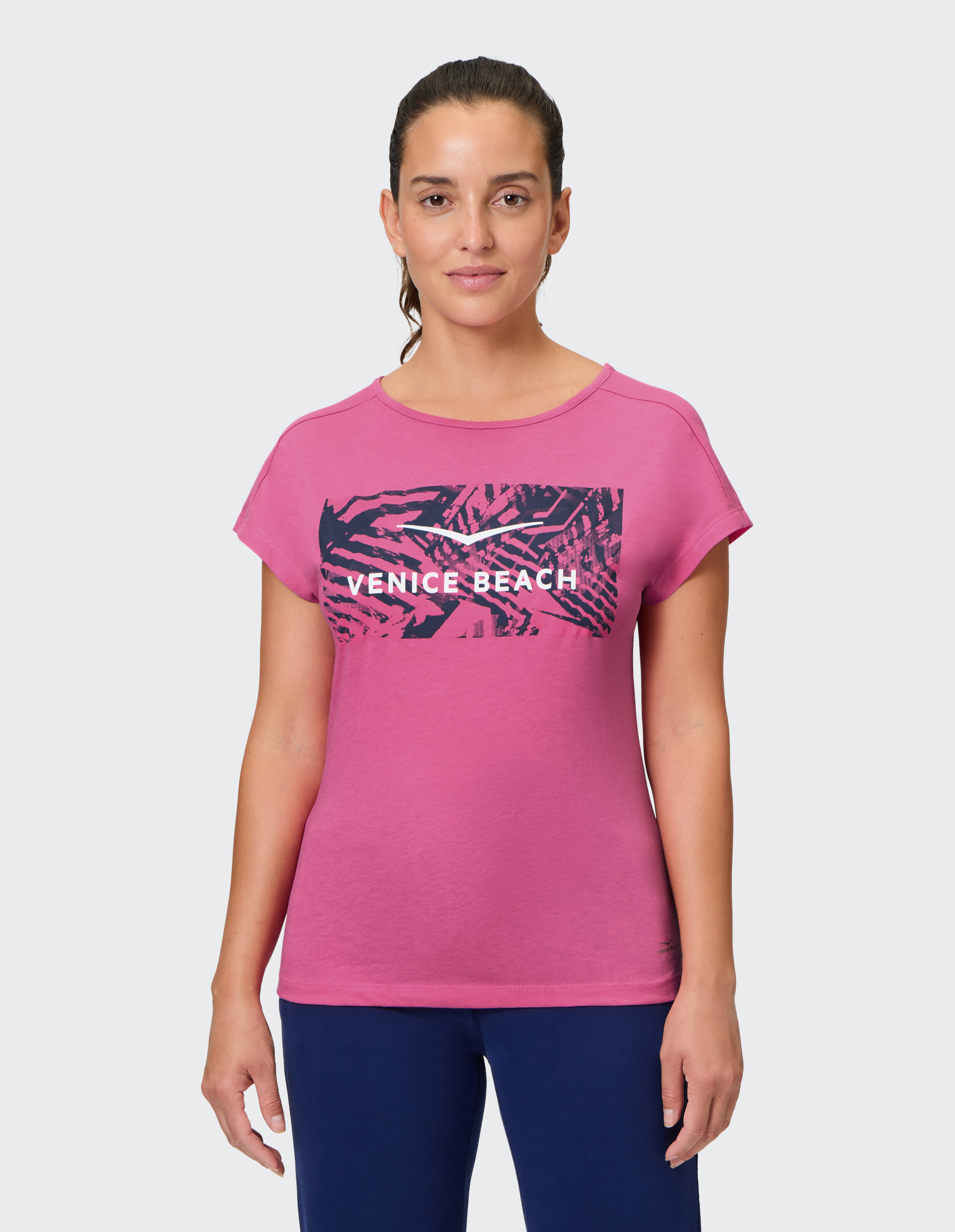 Frau trägt ein rosafarbenes Venice Beach Kurzarmshirt Tia mit grafischem Aufdruck.