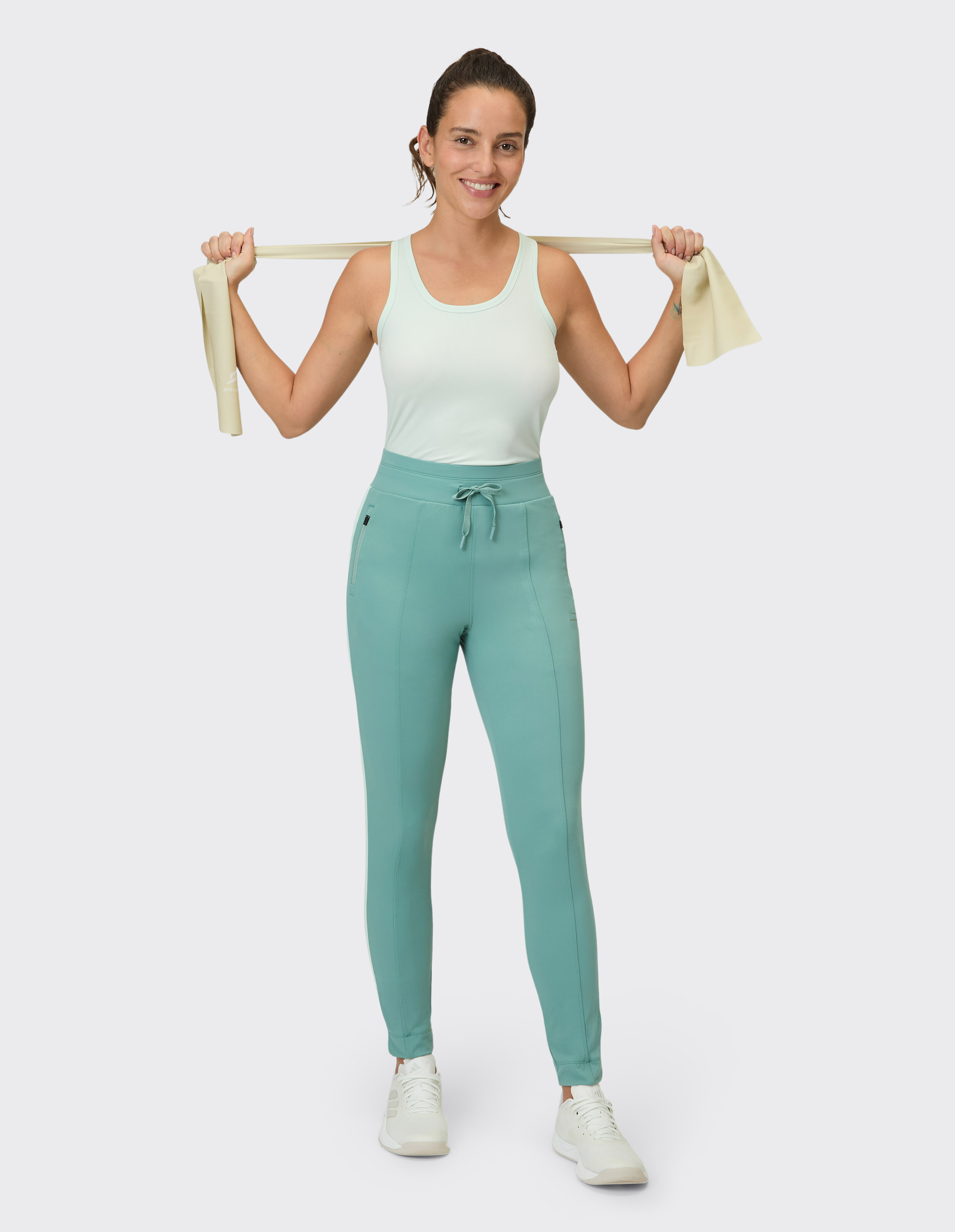 Frau trägt das Venice Beach Tanktop Brenda in Hellgrün für lässige Aktivkleidung.