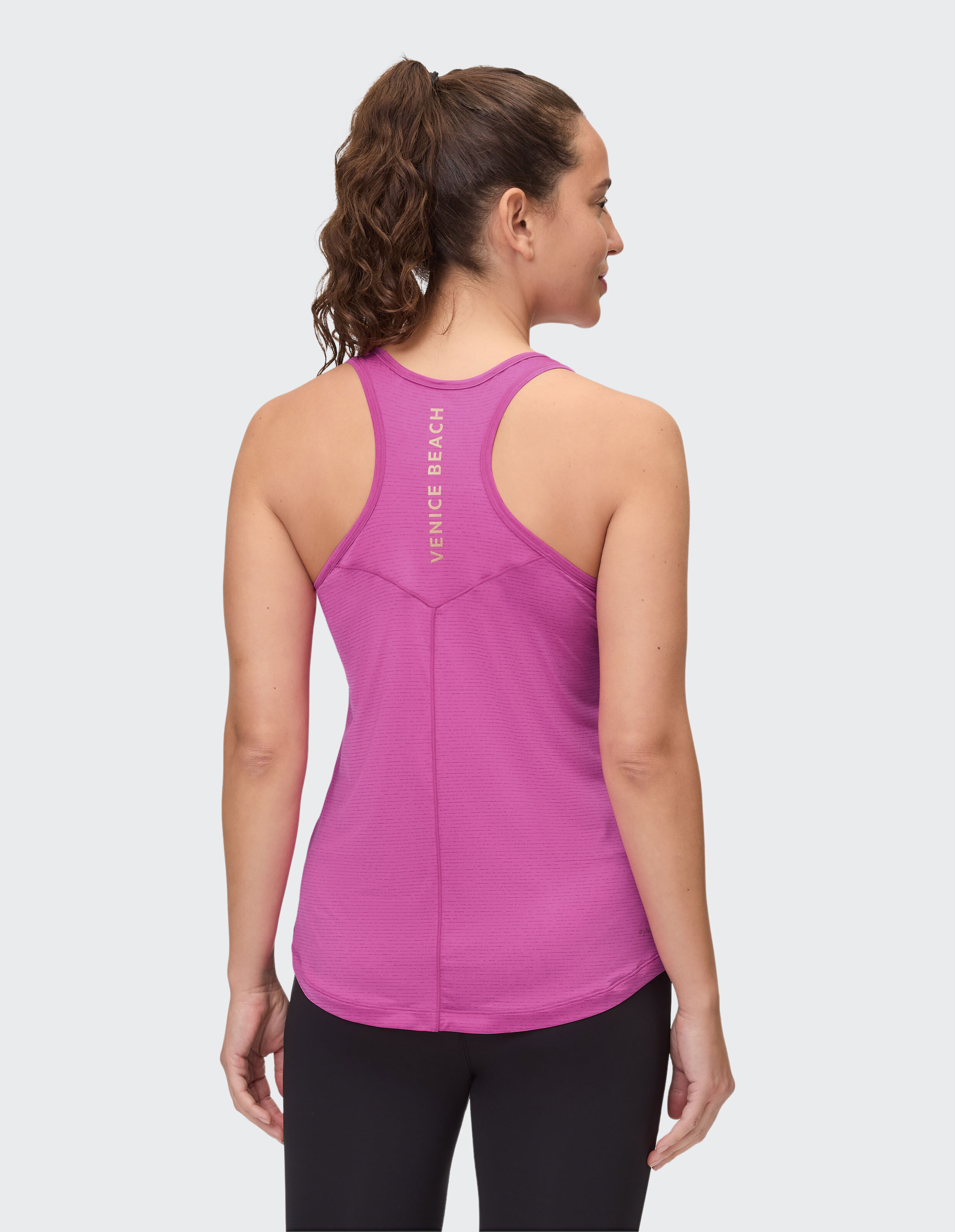 Rückansicht einer Frau, die ein rosa Tanktop trägt, ideal für Freizeitkleidung.