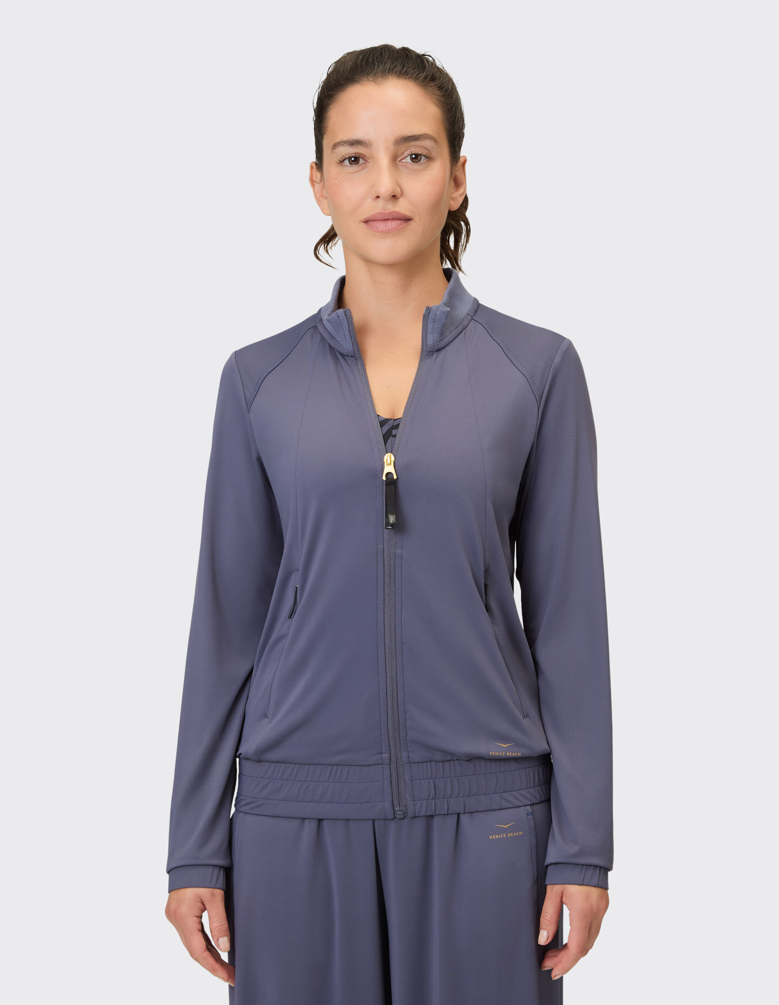 Frau trägt eine stilvolle graue Jacke mit Reißverschluss und entspannter Passform, perfekt für Freizeitausflüge oder zum Faulenzen.