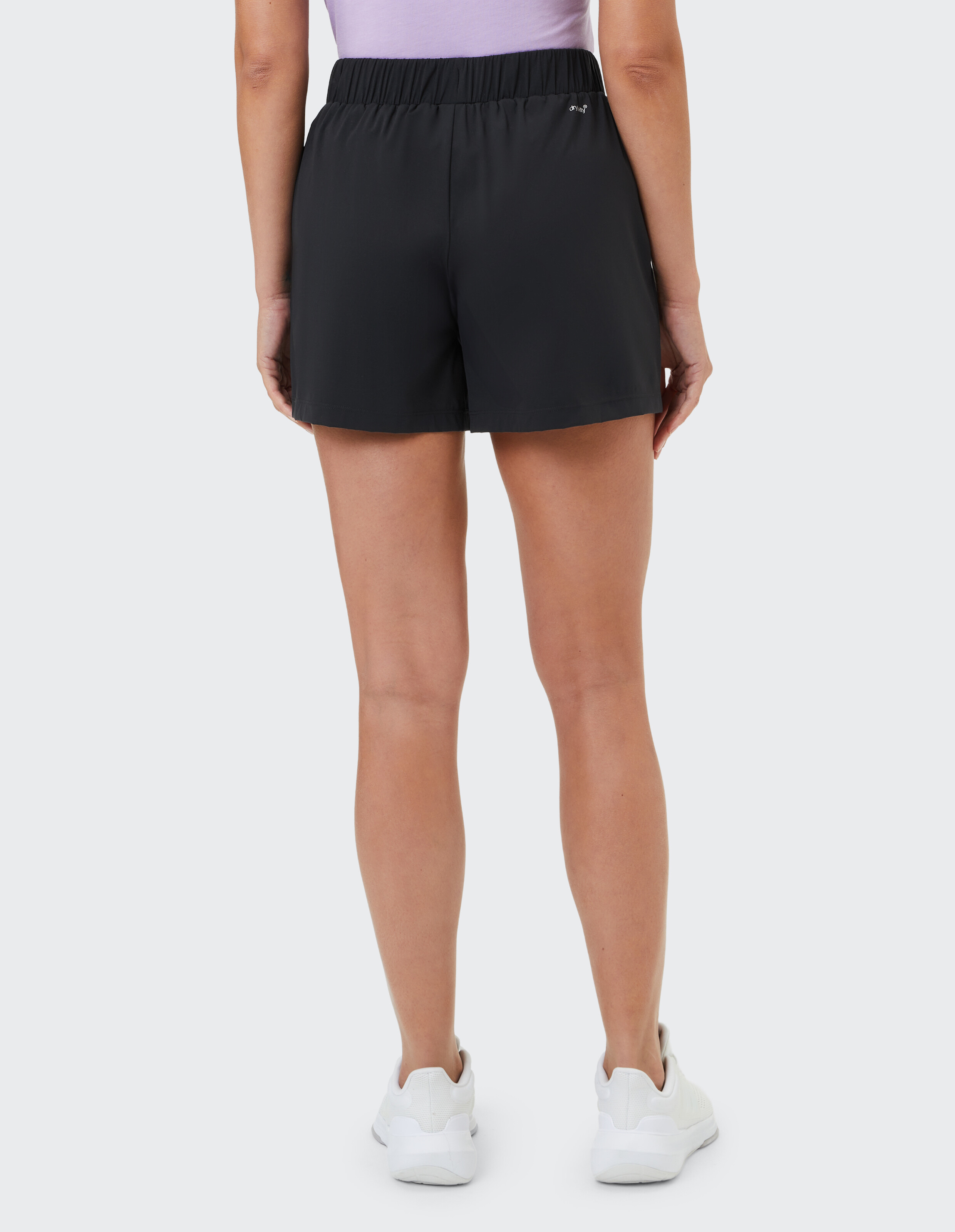 Rückansicht einer Frau in schwarzen Freizeitshorts, perfekt zum Faulenzen oder für sportliche Aktivitäten.