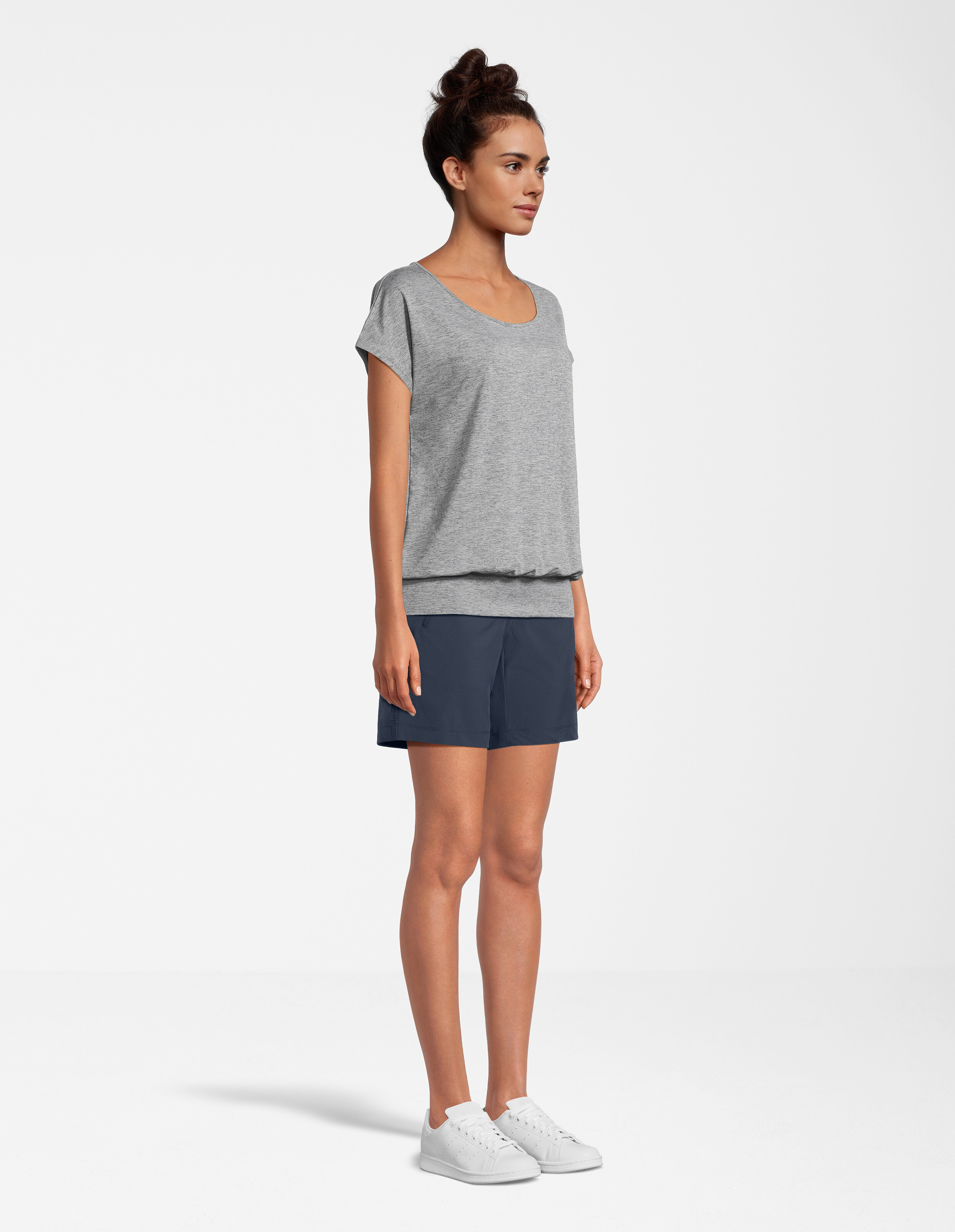 Das Model trägt ein graues, kurzärmliges Oberteil und dunkelblaue Shorts, die für lässigen Komfort sorgen.