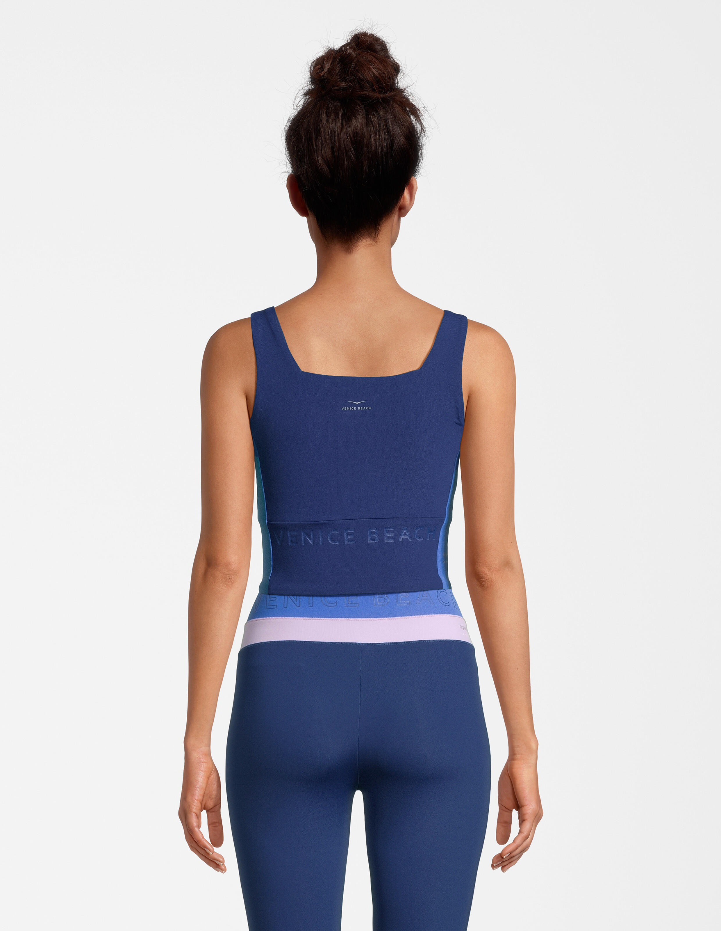 Rückansicht einer Frau in einem marineblauen Sporttop und passenden Leggings.