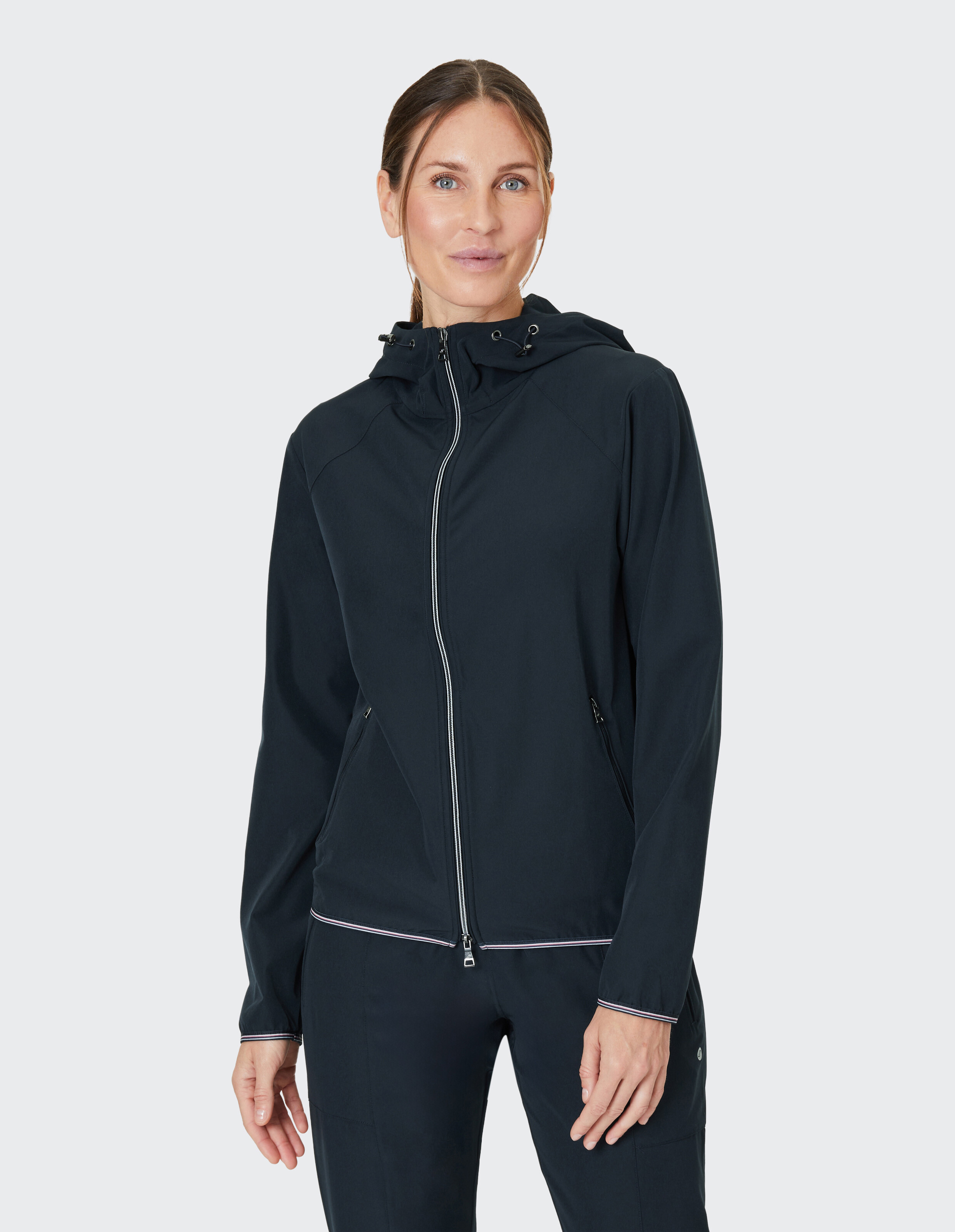 Frau trägt eine dunkelblaue Kapuzenjacke mit Reißverschluss für einen lässigen, bequemen Alltagsstil.