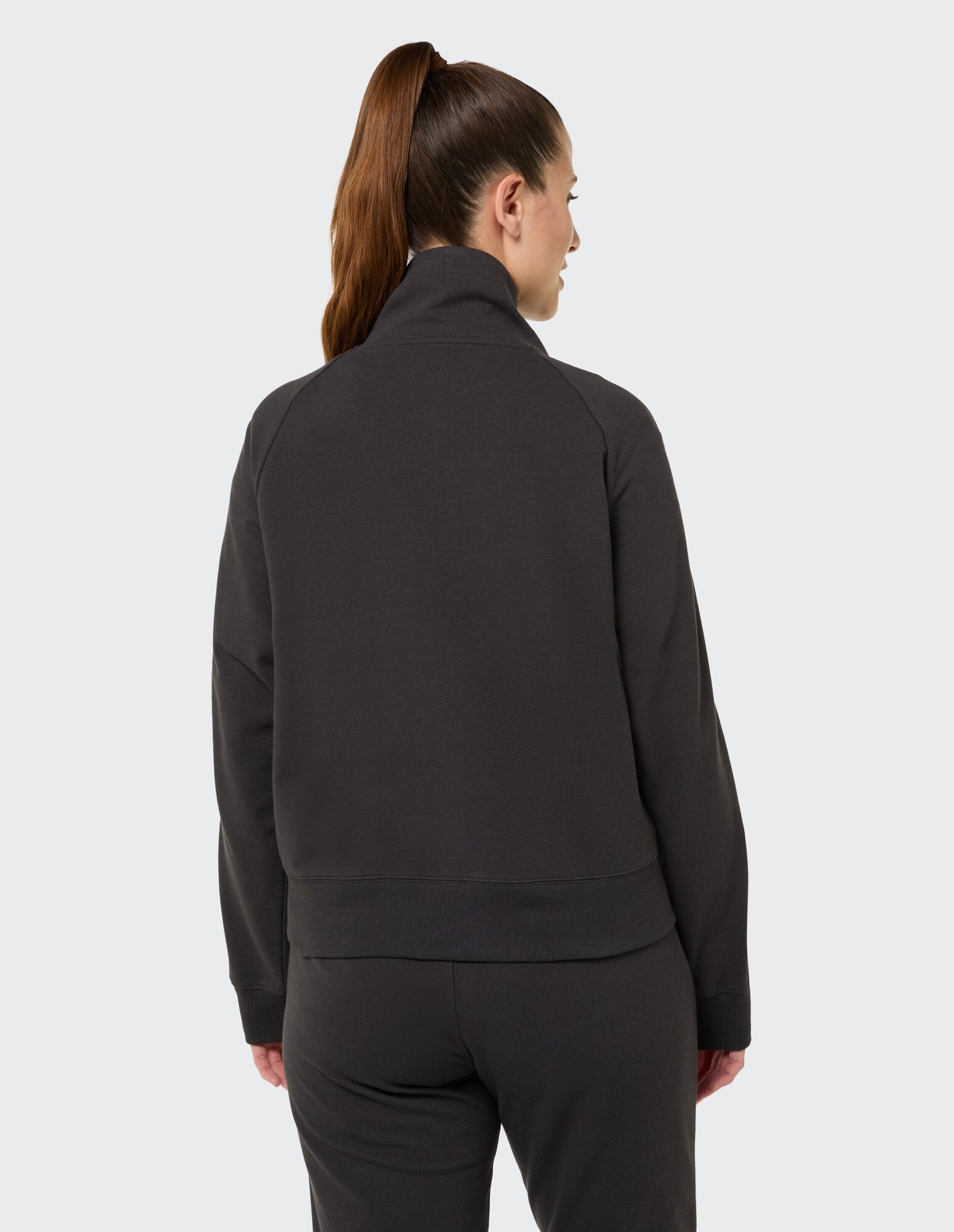 Rückansicht einer Frau in einem dunkelgrauen, lässigen Sweatshirt mit hohem Kragen.