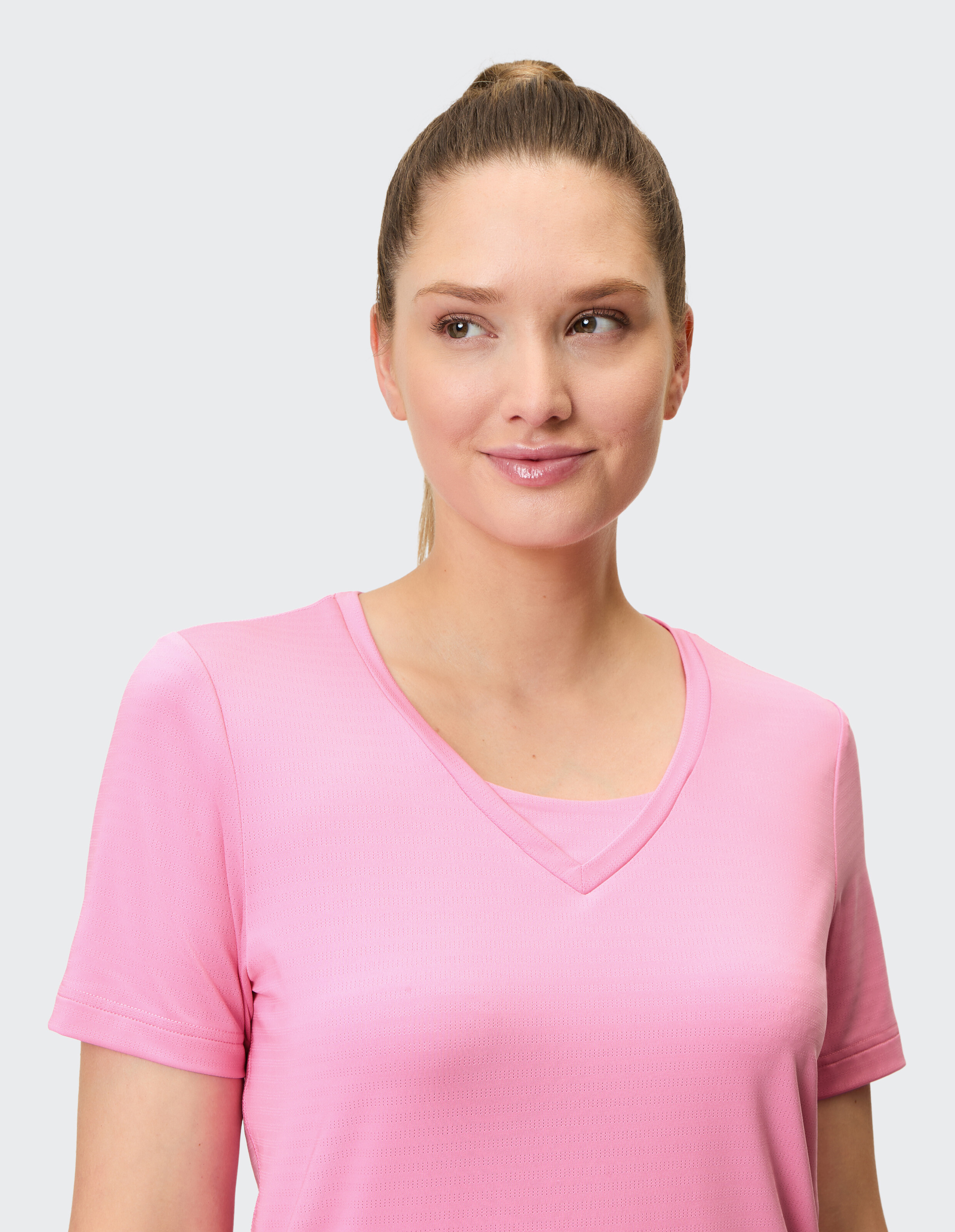 Frau trägt ein kuscheliges rosa T-Shirt mit V-Ausschnitt für lässige Alltags-Loungewear.