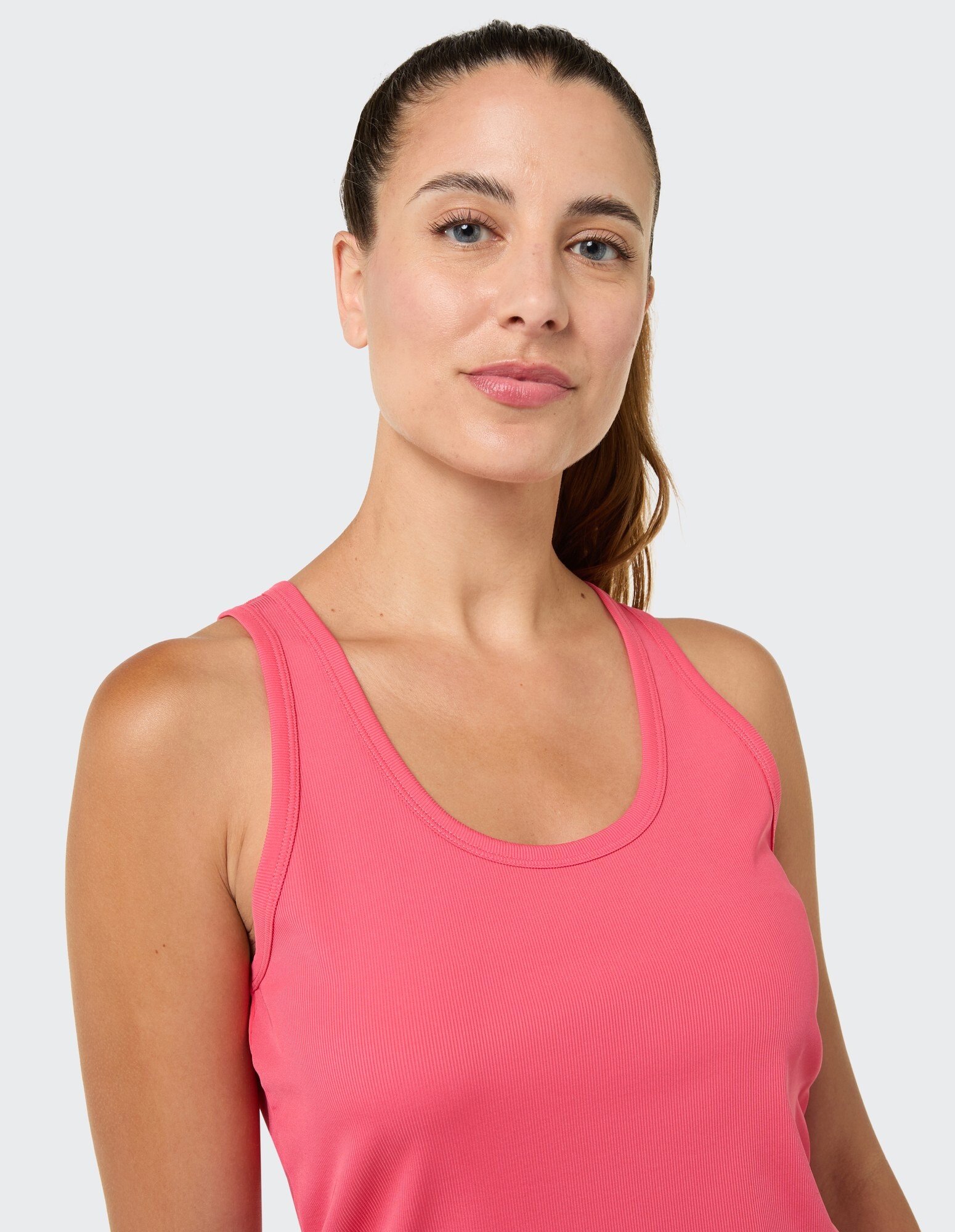 Das Model trägt ein rosa geripptes Tanktop und zeigt einen lässigen und bequemen Stil.