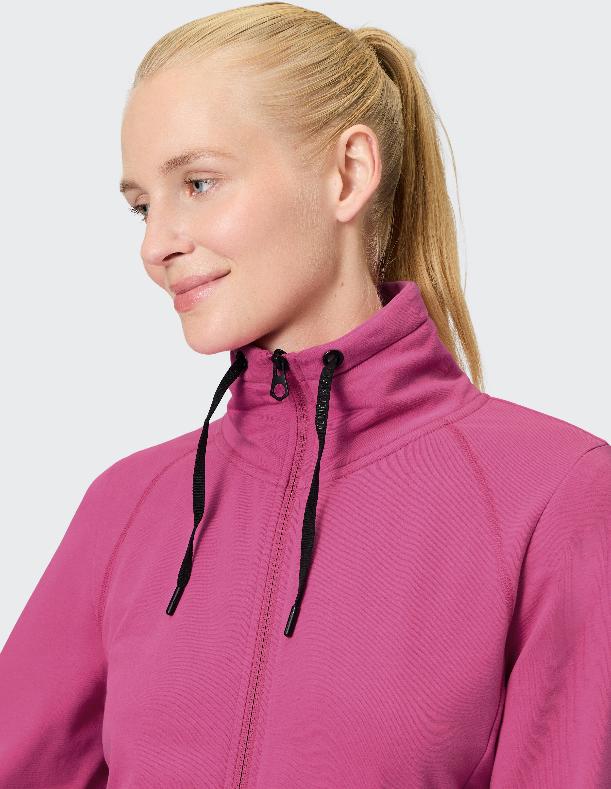 Frau trägt eine kuschelige rosa Sweatjacke von Venice Beach Florence mit hohem Kragen.