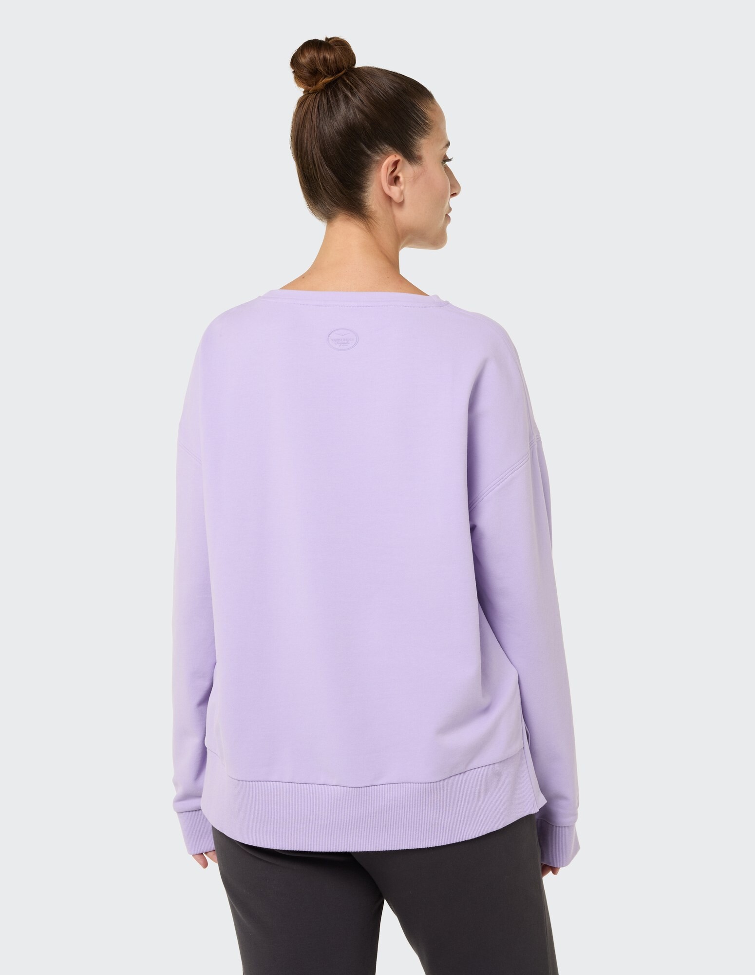 Rückansicht einer Frau in einem lila übergroßen Sweatshirt, perfekt für Freizeitkleidung.