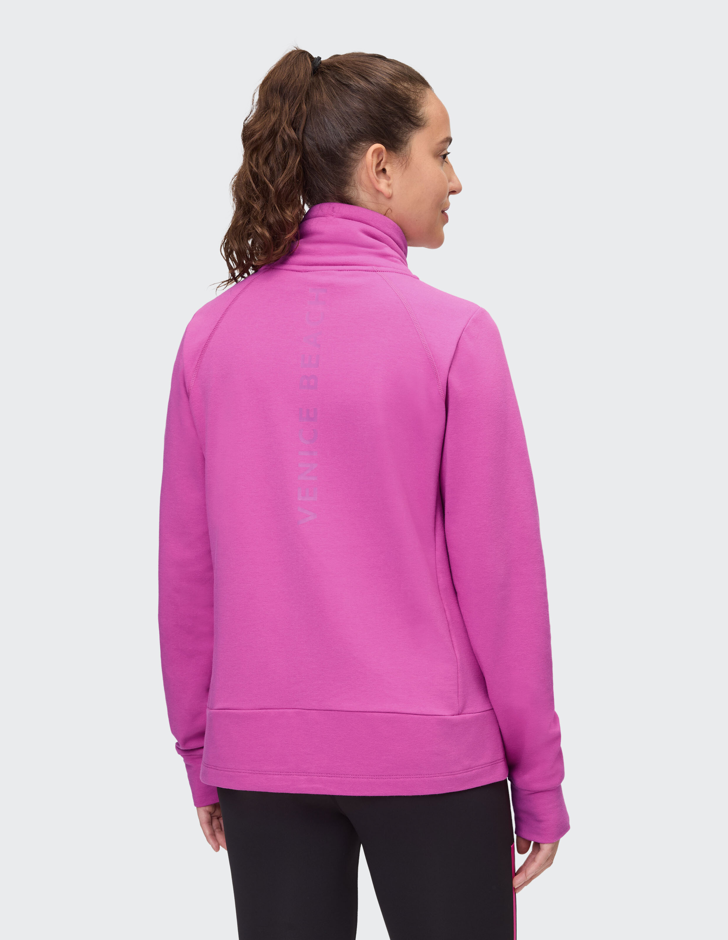 Frau trägt ein kuscheliges rosa ELBSAND-Sweatshirt mit Reißverschluss und hohem Kragen für lässigen Stil.