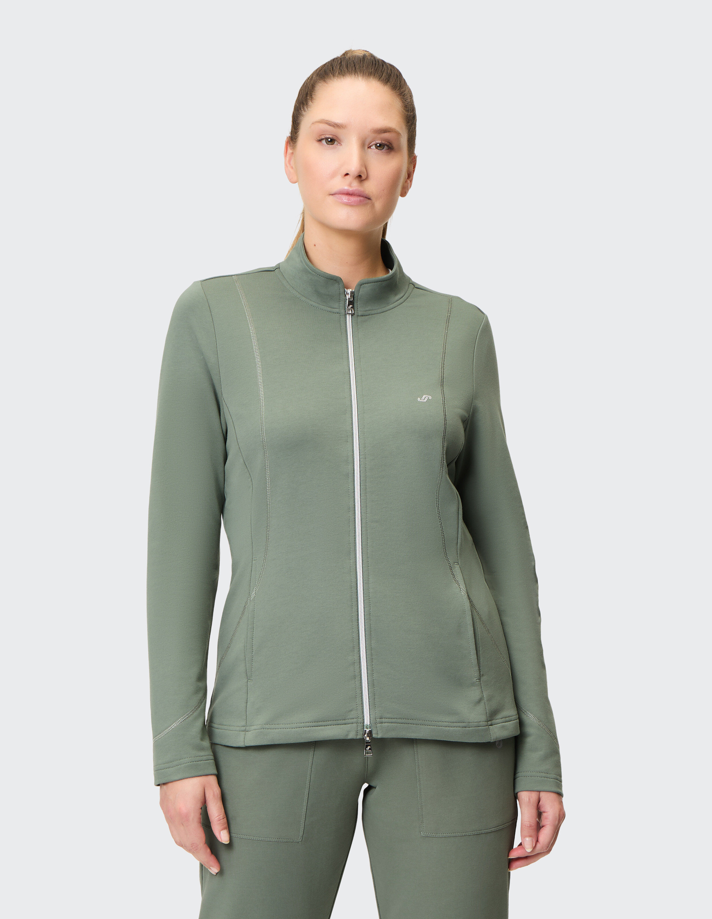 Dunkelgrüne Damenjacke mit Reißverschluss und Stehkragen, dezentem Logo auf der Brust und zwei seitlichen Nähten als Design-Elemente.