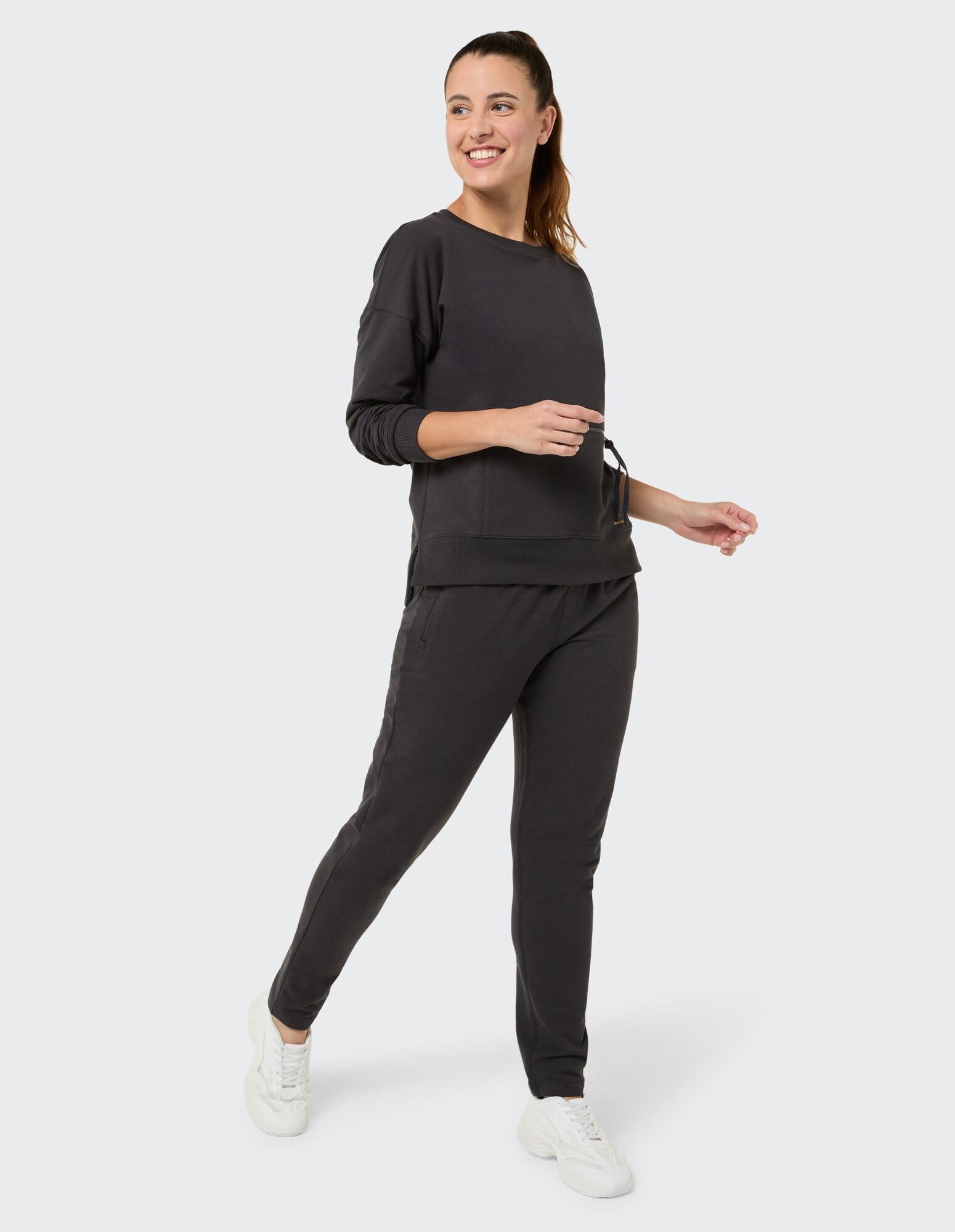 Frau in einem kuscheligen schwarzen Sweatshirt und passenden Jogginghosen, perfekt für Freizeitkleidung.