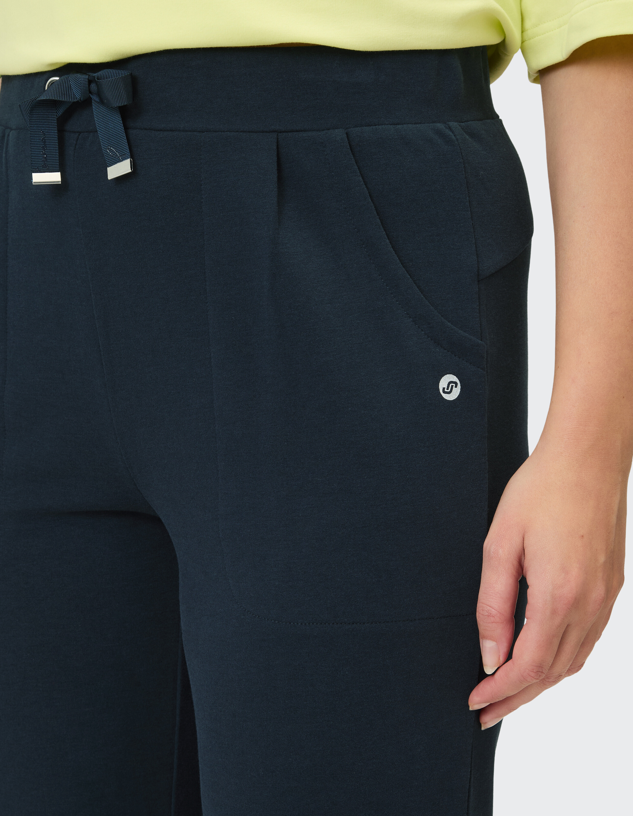Nahaufnahme einer marineblauen Freizeithose mit Taschen und Kordelzug in der Taille.