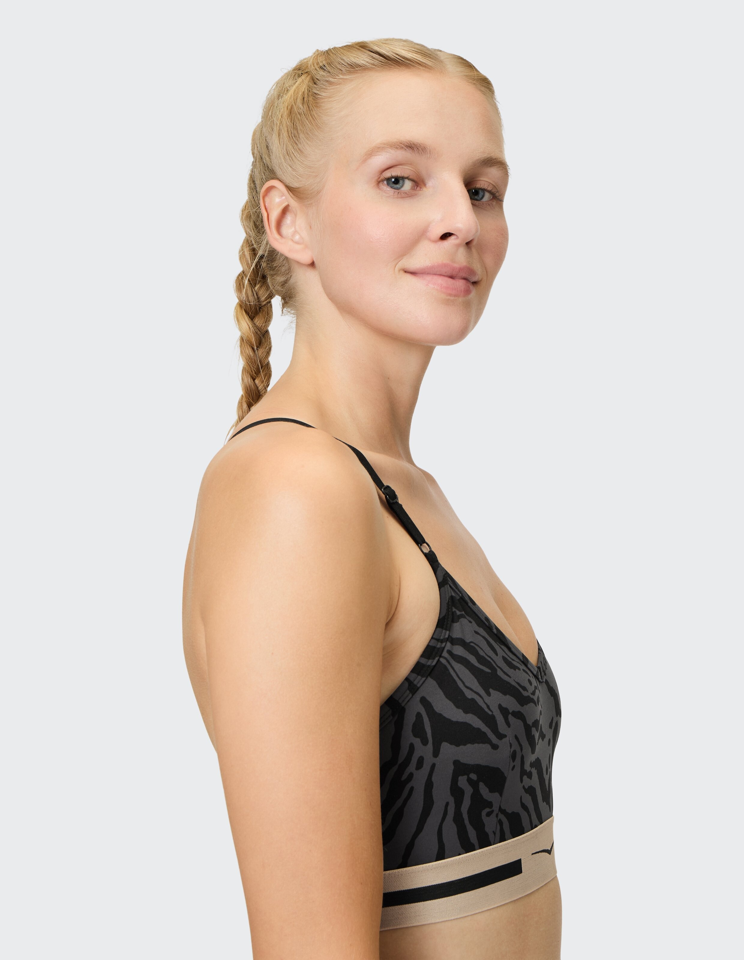 Frau trägt einen kuscheligen, schwarz-grau gemusterten Top-Oakley-Lounge-BH.
