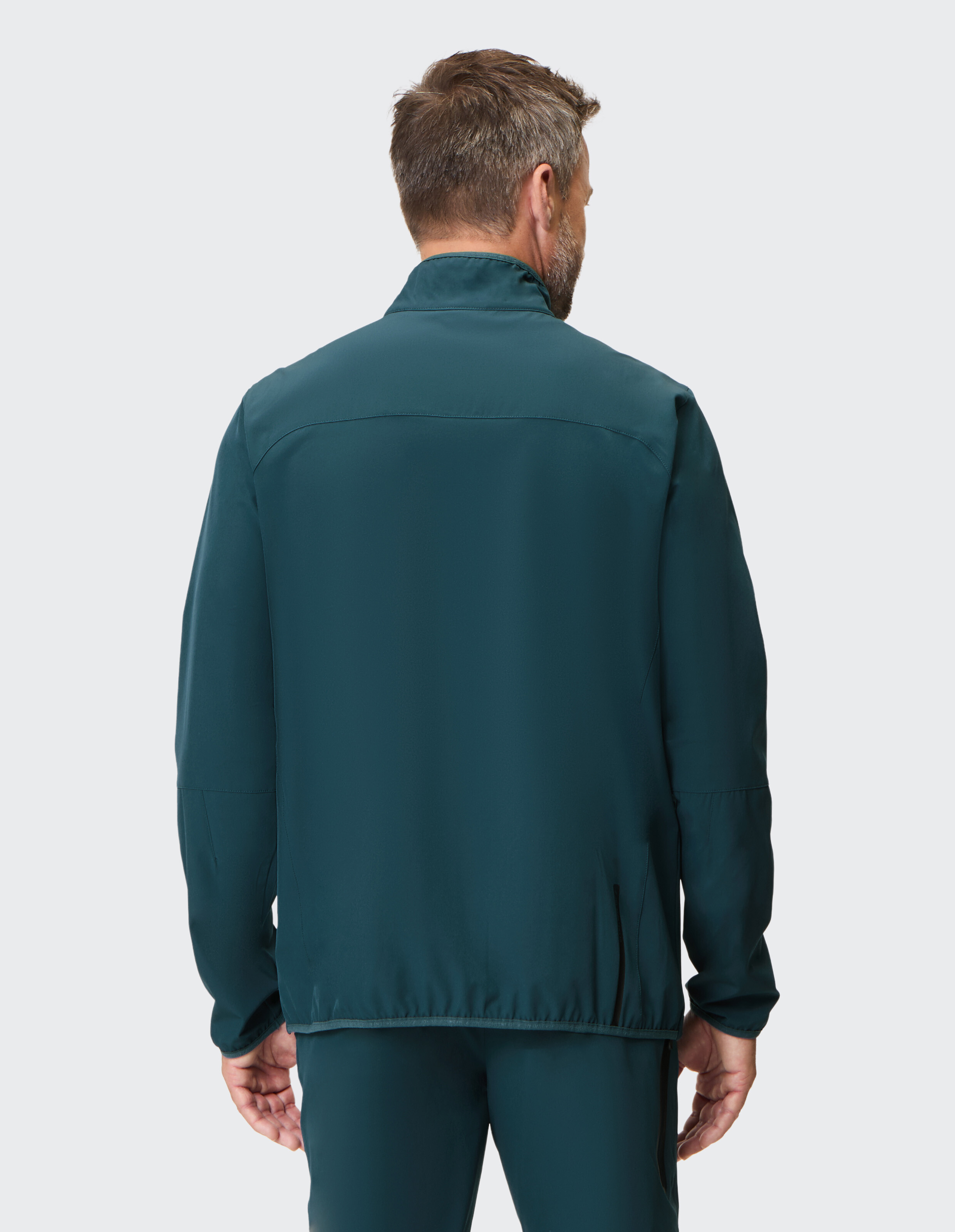 Mann trägt eine dunkelblaue, lässige Jacke mit Reißverschluss, Rückansicht, bequemer Loungewear-Stil.