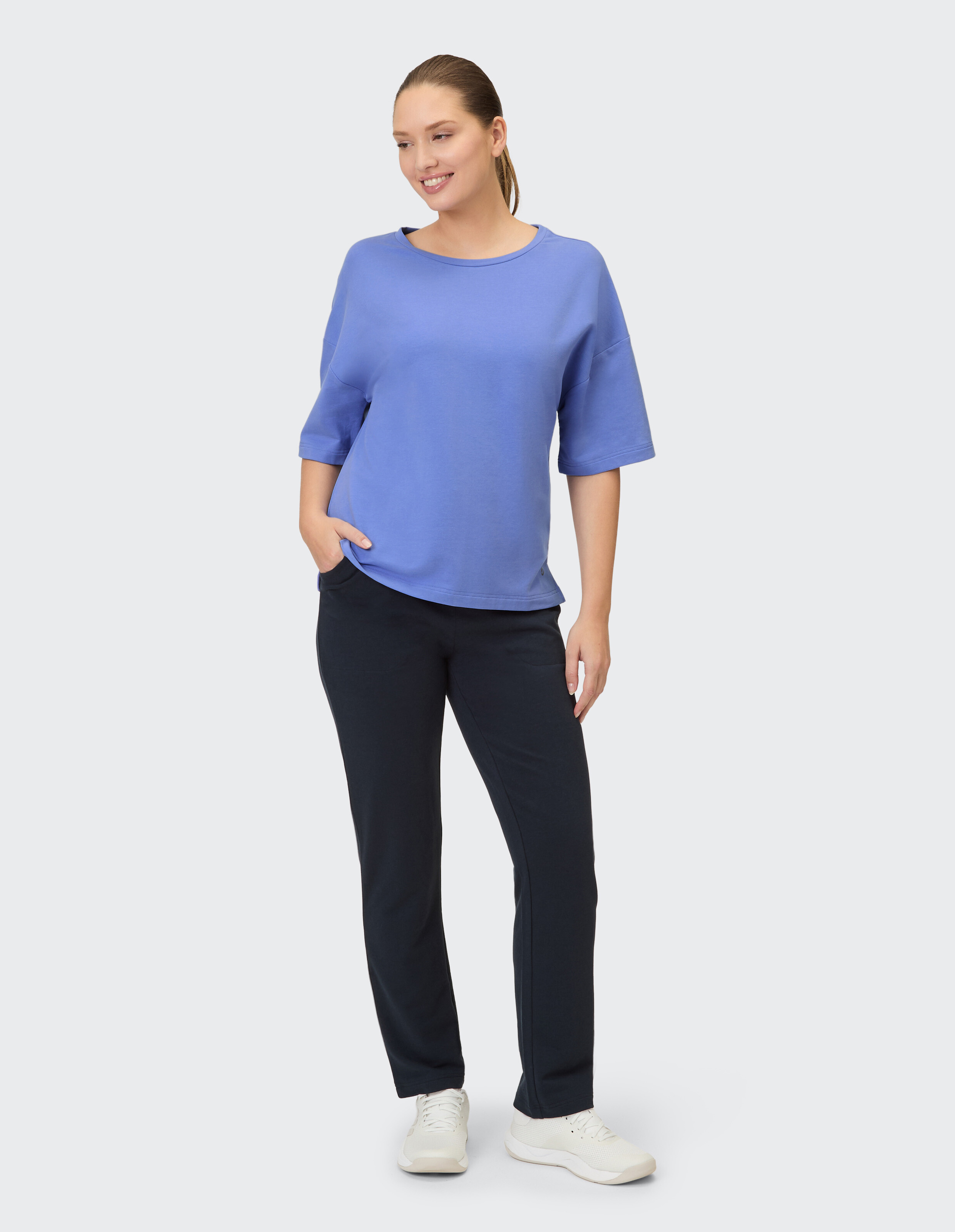 Frau in einem blauen Freizeitoberteil und einer dunkelblauen Hose, perfekt für entspannte Ausflüge.