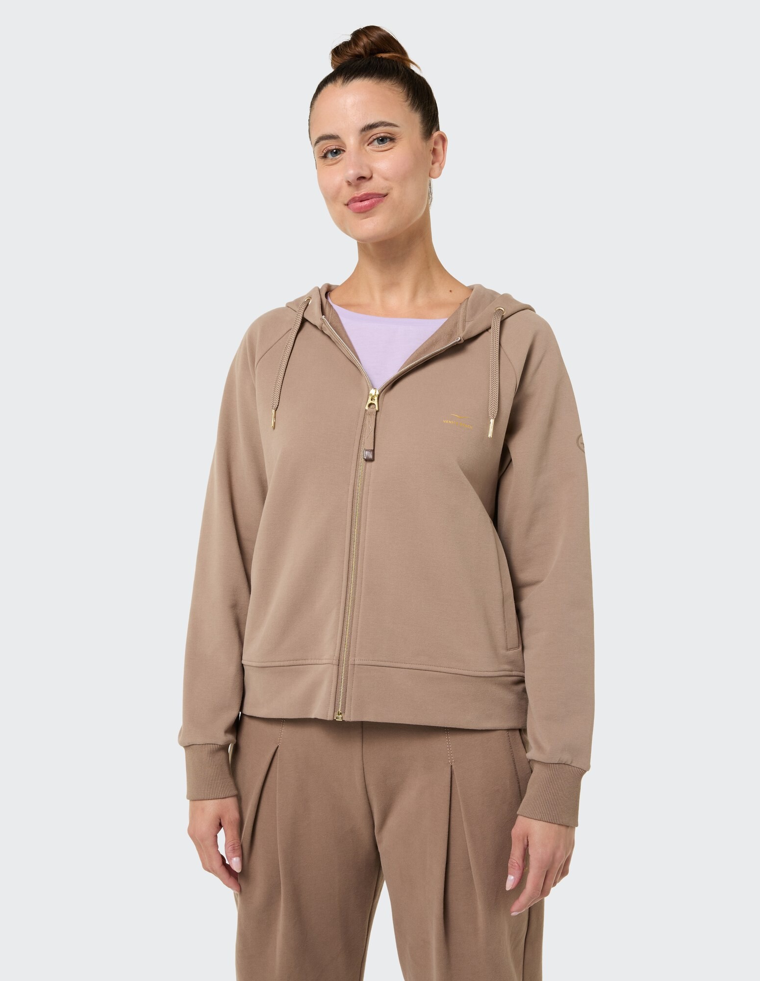 Gemütlicher beigefarbener Kapuzenpullover mit Reißverschluss und goldenen Akzenten, perfekt für die Freizeit.