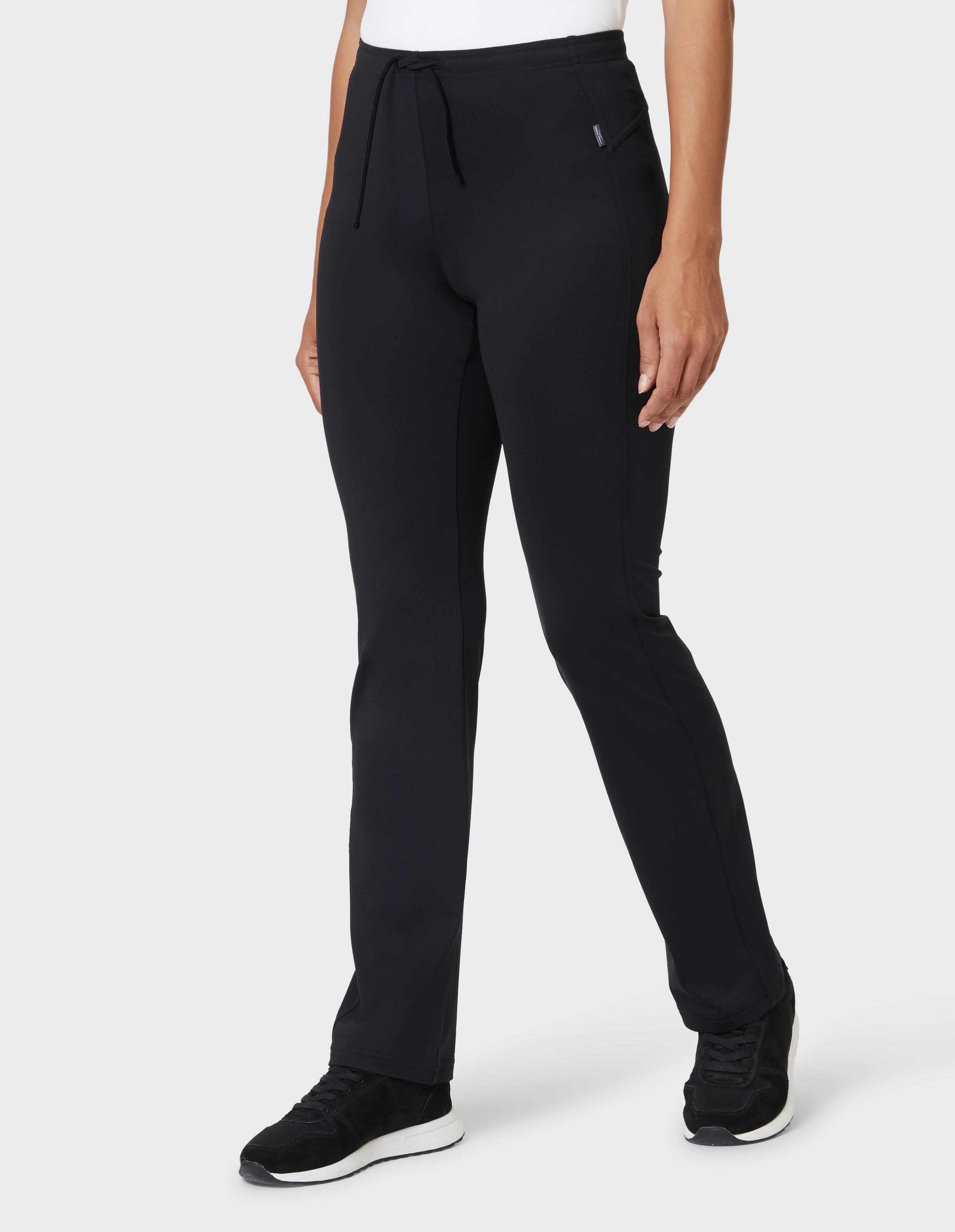 Frau trägt bequeme schwarze Freizeithose mit Kordelzug in der Taille.