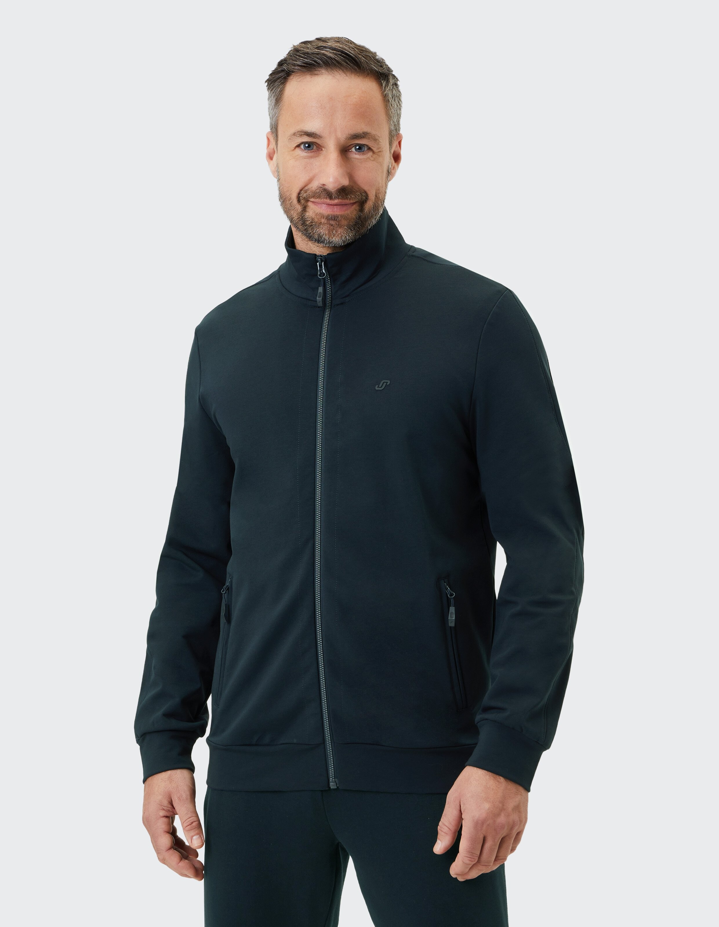 Schwarze Trainingsjacke mit hohem Kragen, durchgehendem Reißverschluss und seitlichen Reißverschlusstaschen auf weißem Hintergrund.