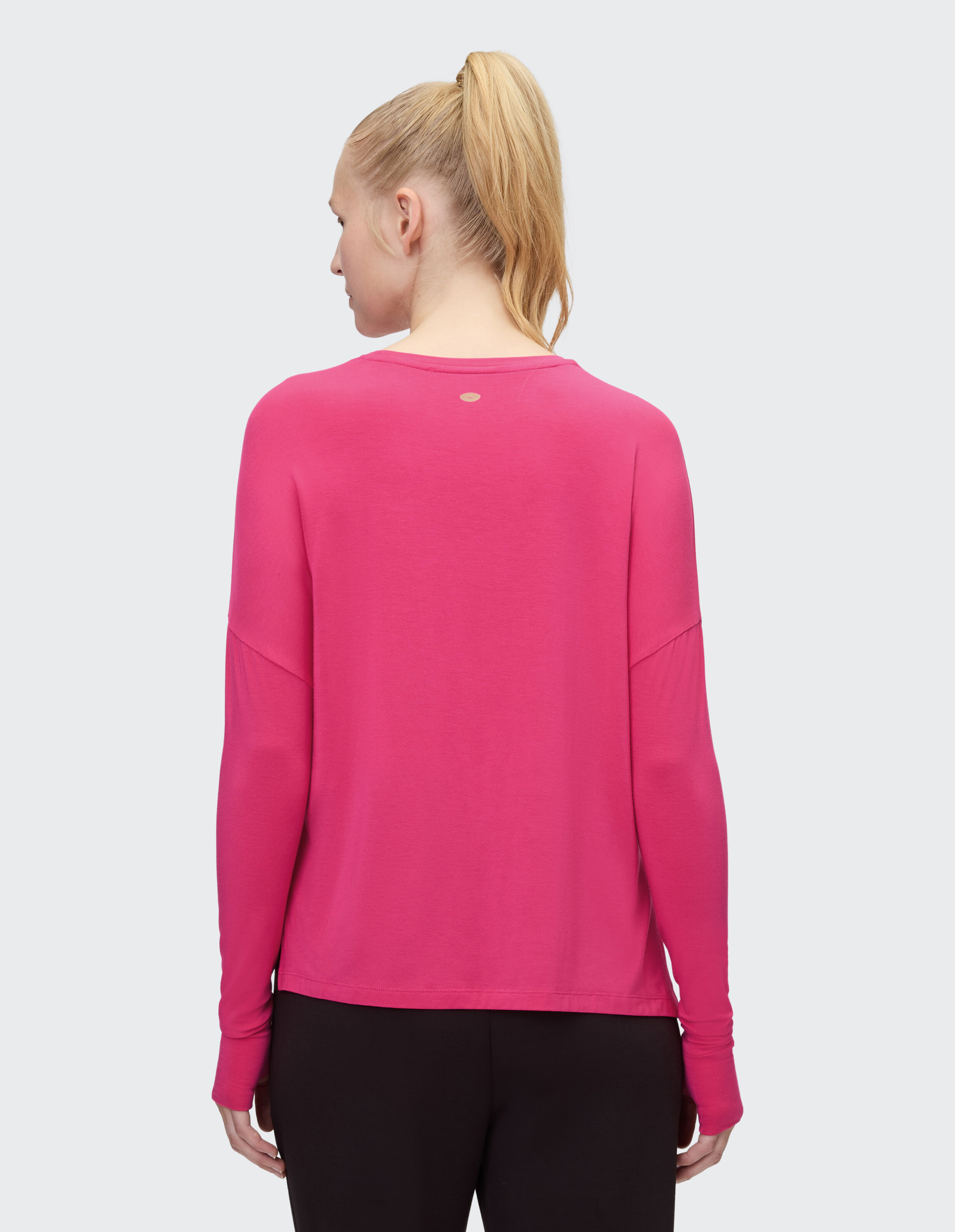 Rückansicht einer Frau in einem rosa Langarmshirt, perfekt für Freizeitkleidung.