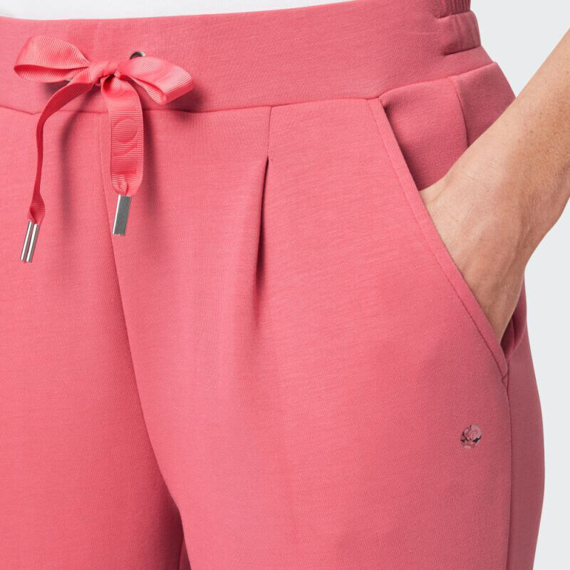 Nahaufnahme einer rosafarbenen Freizeithose mit Falten und Kordelzugdetail.
