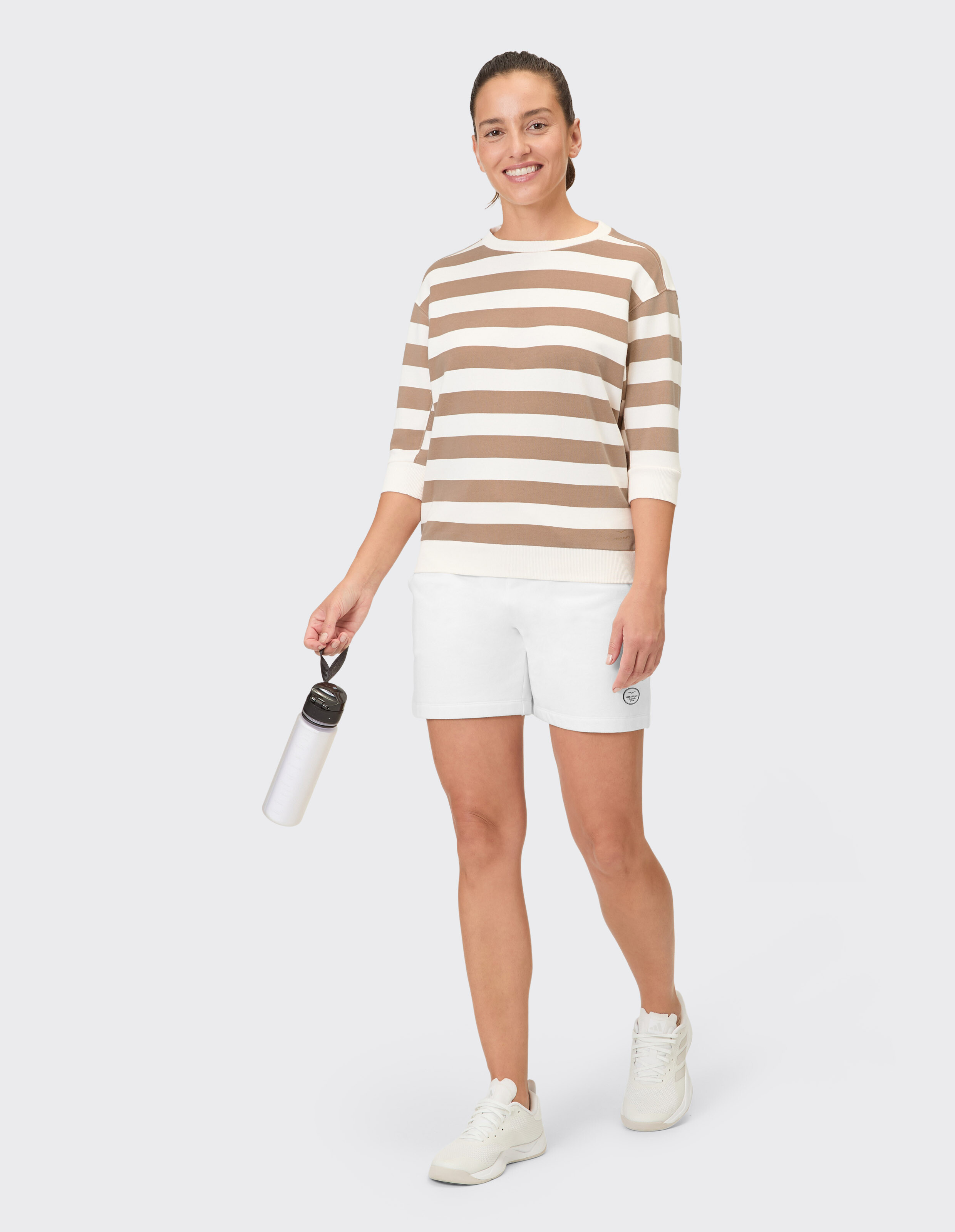 Frau trägt die Venice Beach Shorts Morla und ein gestreiftes Oberteil für einen lässigen Look.