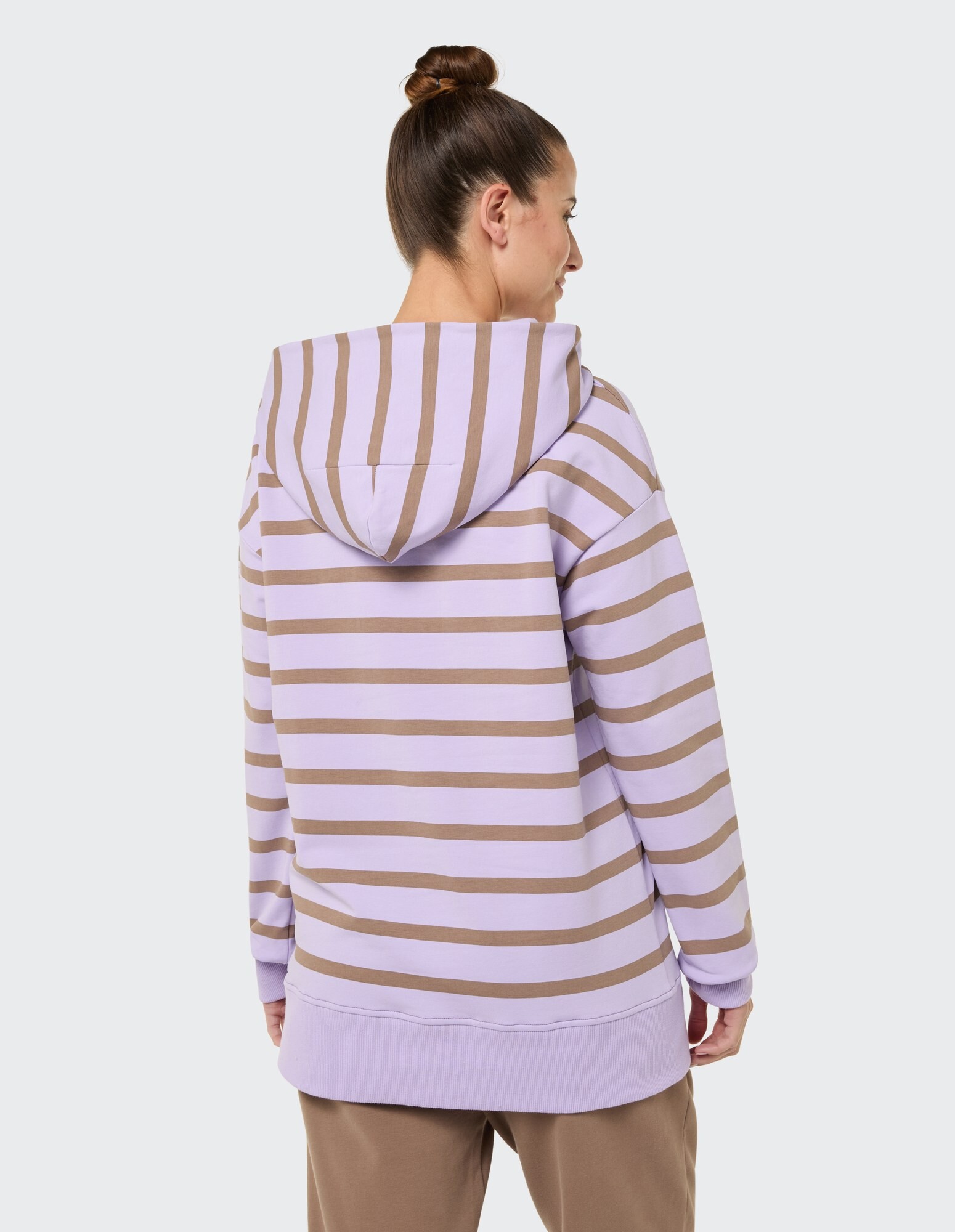 Rückansicht einer Frau in einem gestreiften lavendelfarbenen und braunen Kapuzenpullover im lässigen Stil.