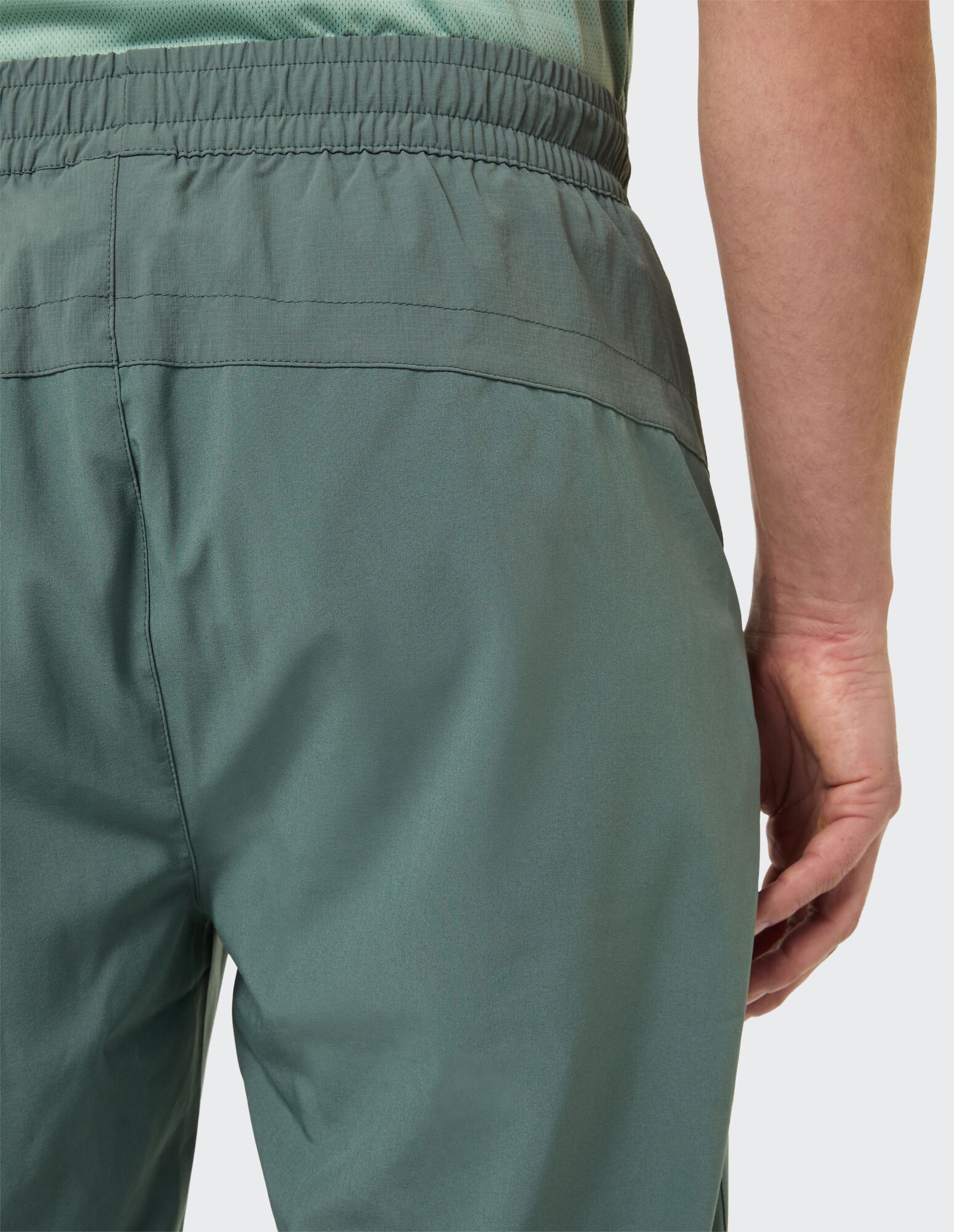 Nahaufnahme einer lässigen grünen Herrenhose mit elastischem Bund und entspannter Passform.