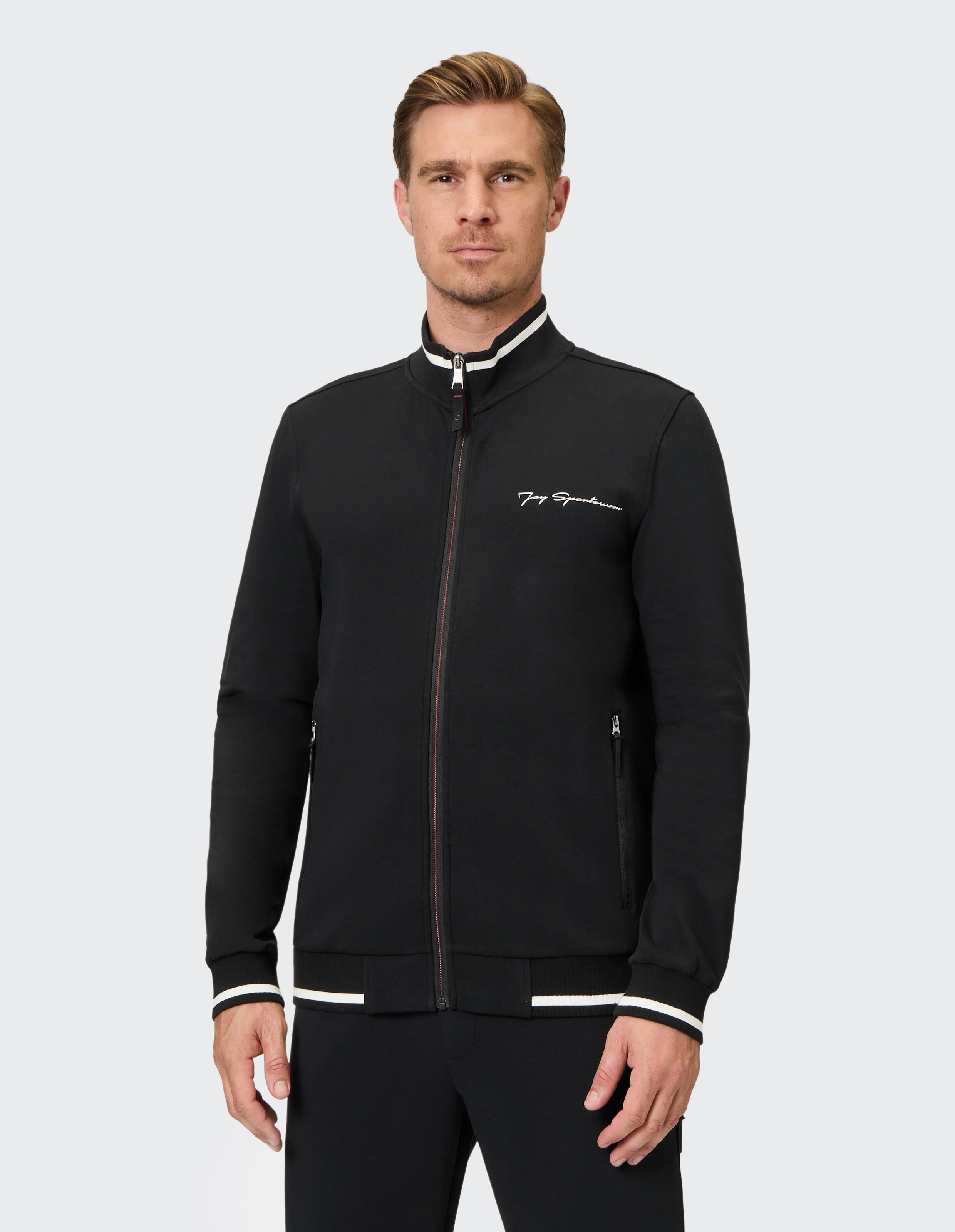 Schwarze Herrenjacke mit Reißverschluss und weißen und roten Akzenten, perfekt für Freizeitkleidung.