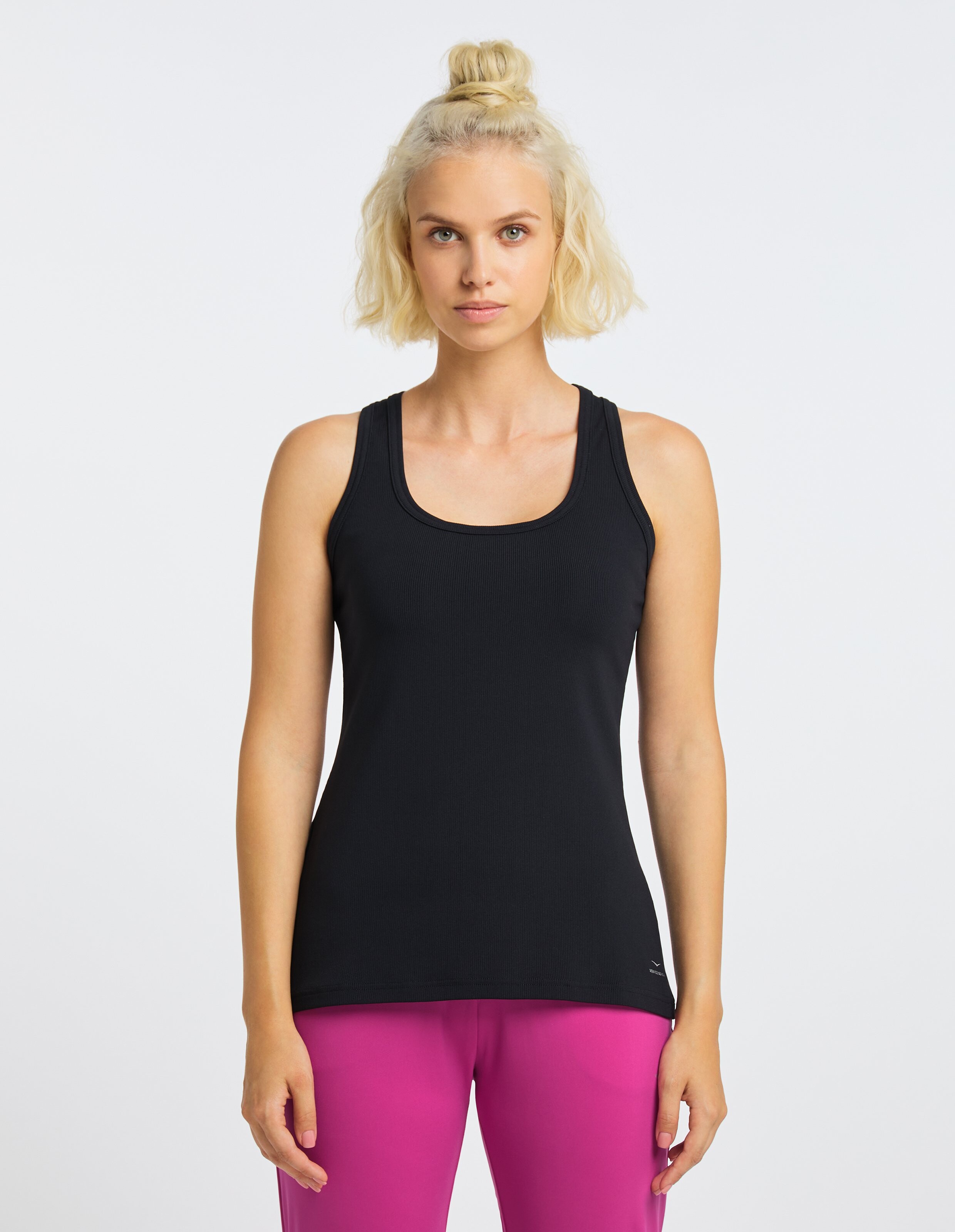 Schwarzes ärmelloses Tanktop für Freizeitkleidung, gepaart mit einer rosa Hose.