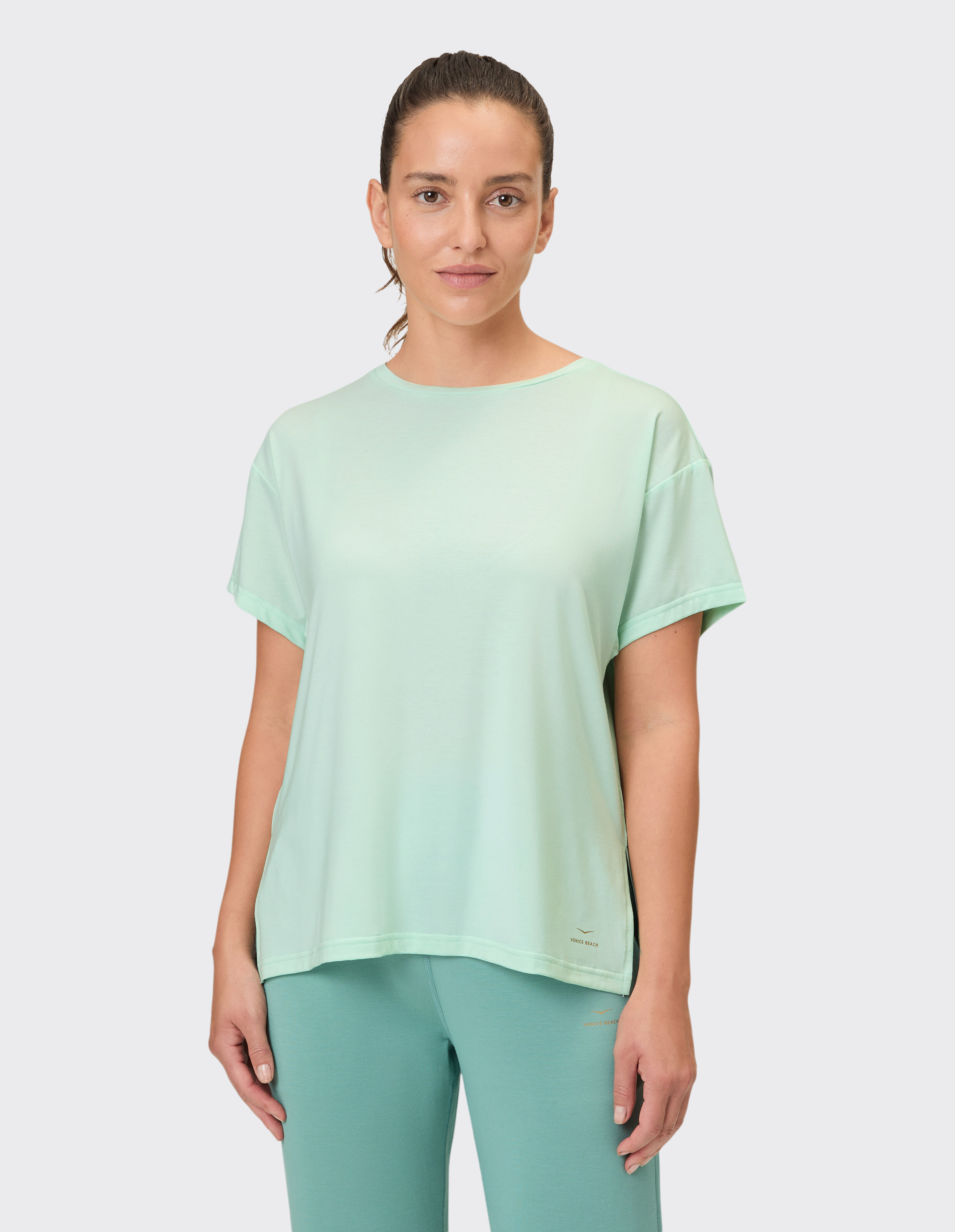 Frau trägt ein hellgrünes, übergroßes Freizeit-T-Shirt für bequeme Loungewear.