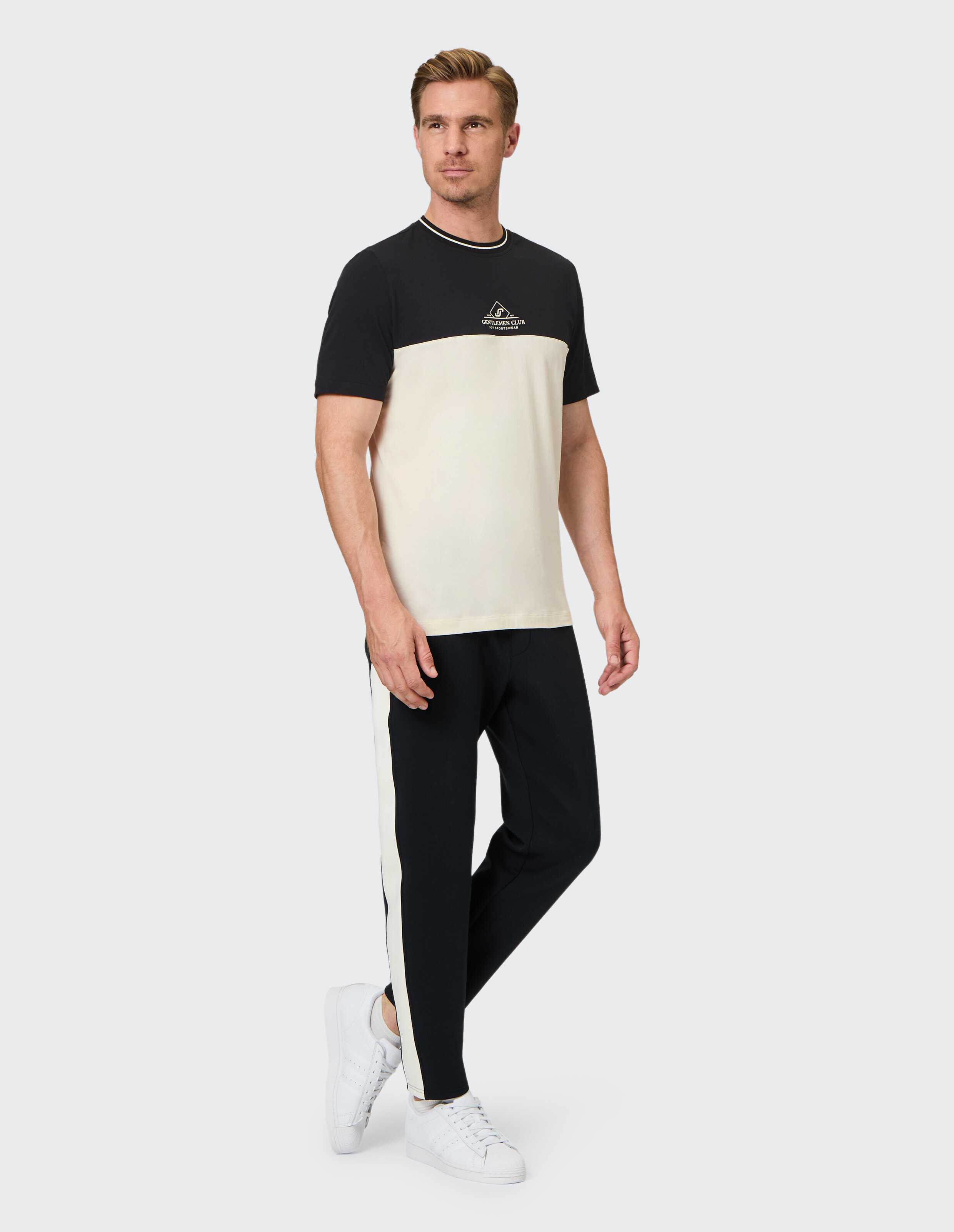 Mann trägt ein lässiges T-Shirt in Colour-Block-Optik und eine passende Hose, ideal für entspannte Ausflüge oder zum Faulenzen.